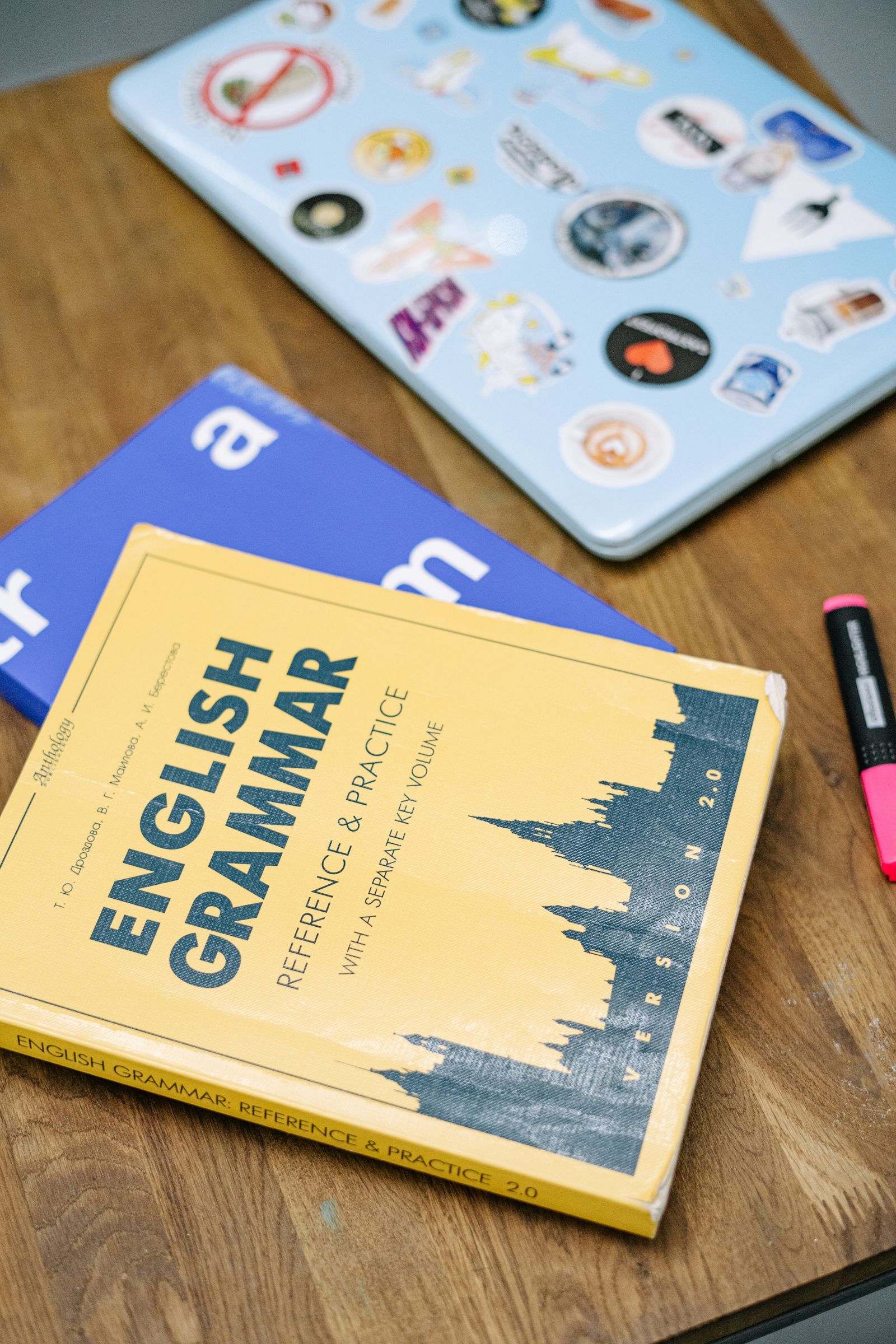 Laptop and books on a wooden table