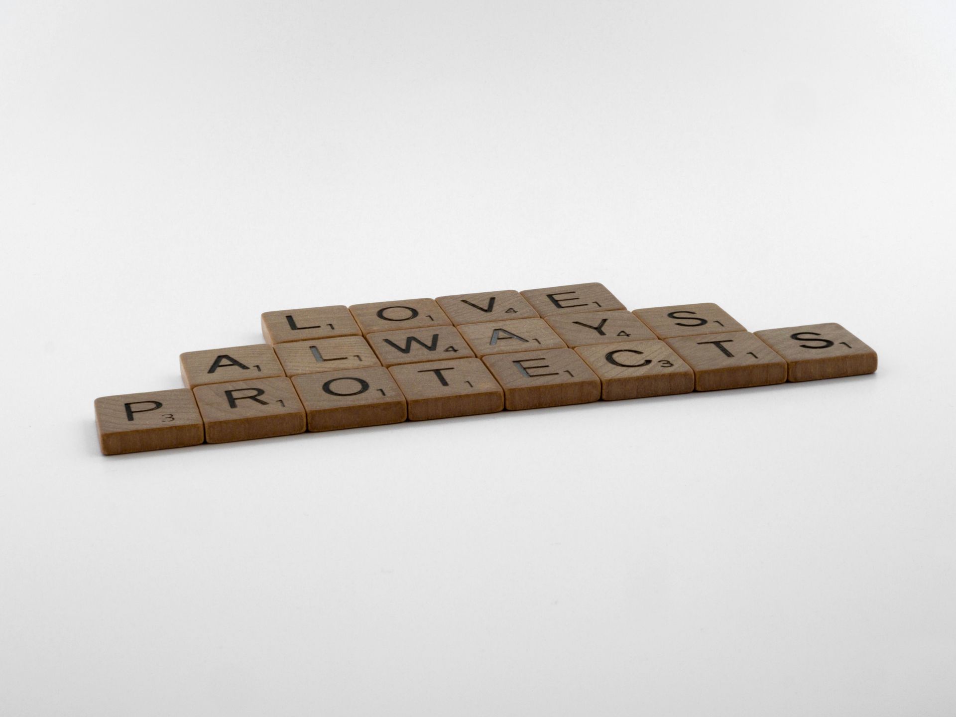 Close-up of Scrabble tiles spelling Love Always Protects