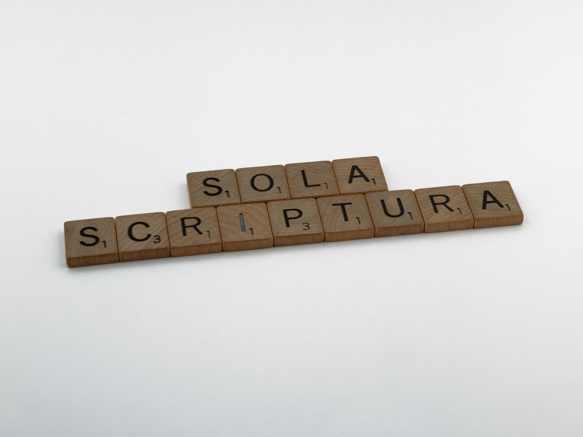Brown wooden Scrabble tiles arranged on a white surface