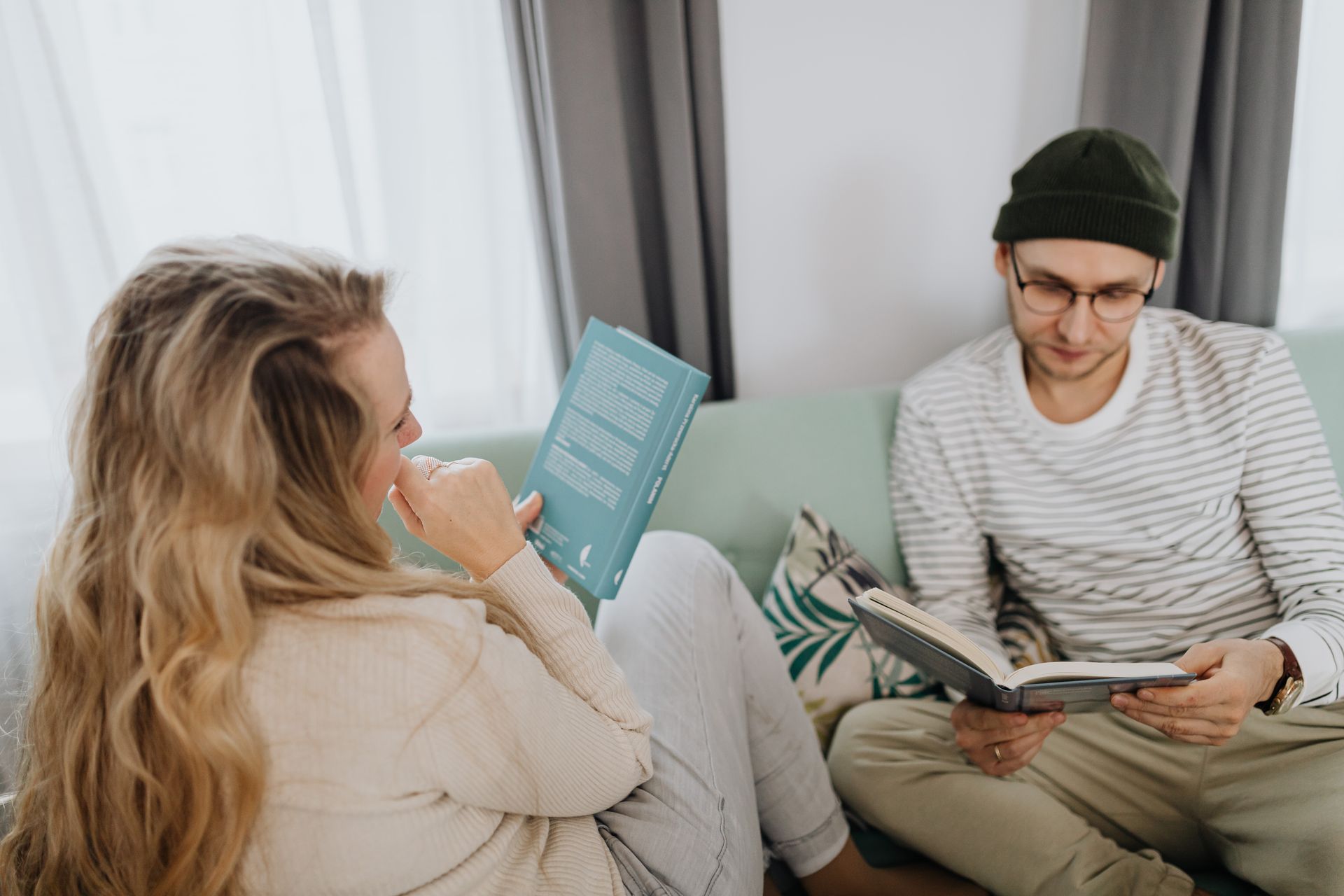 Couple reading books together in a comfortable living room