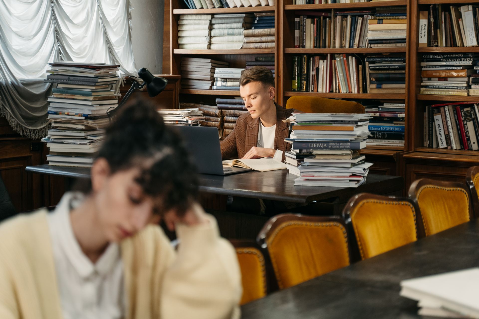 Young man reading in a cozy well-stocked library