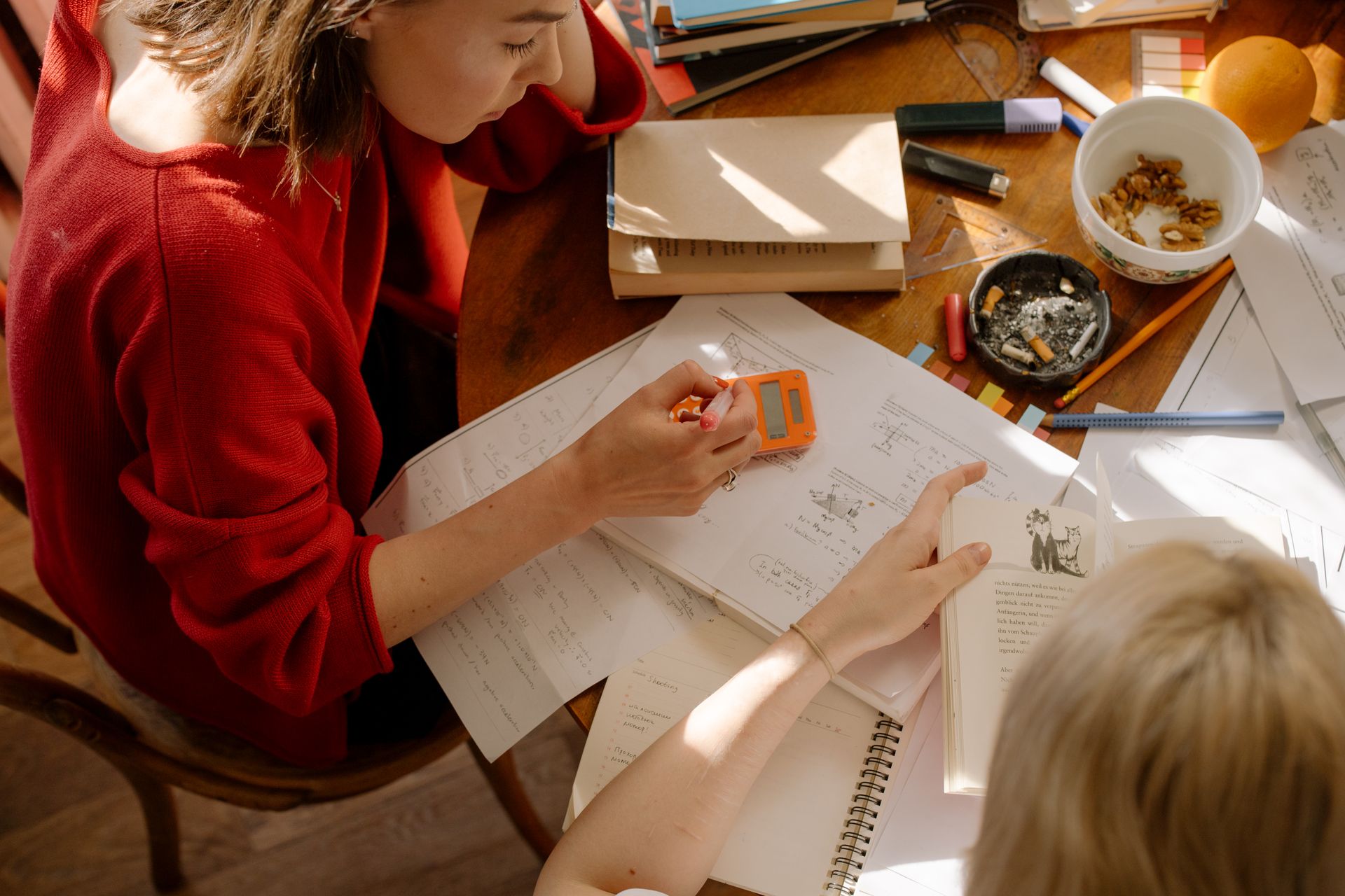 Two students studying together with textbooks and notes