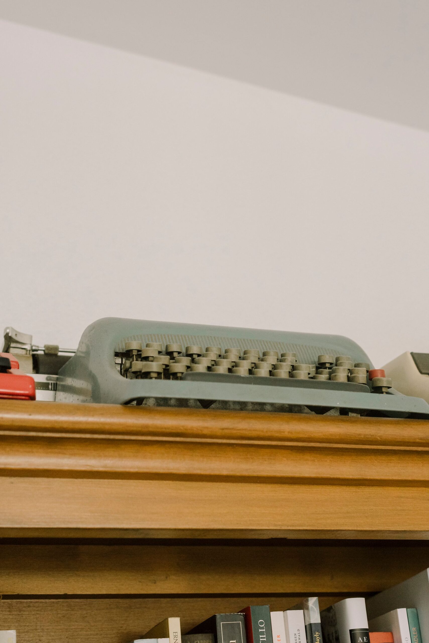 A classic typewriter displayed on a wooden shelf, capturing a nostalgic vintage atmosphere.