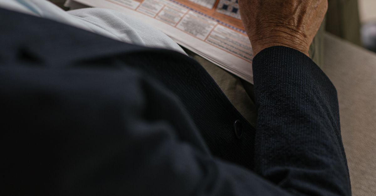 Person holding a newspaper outdoors