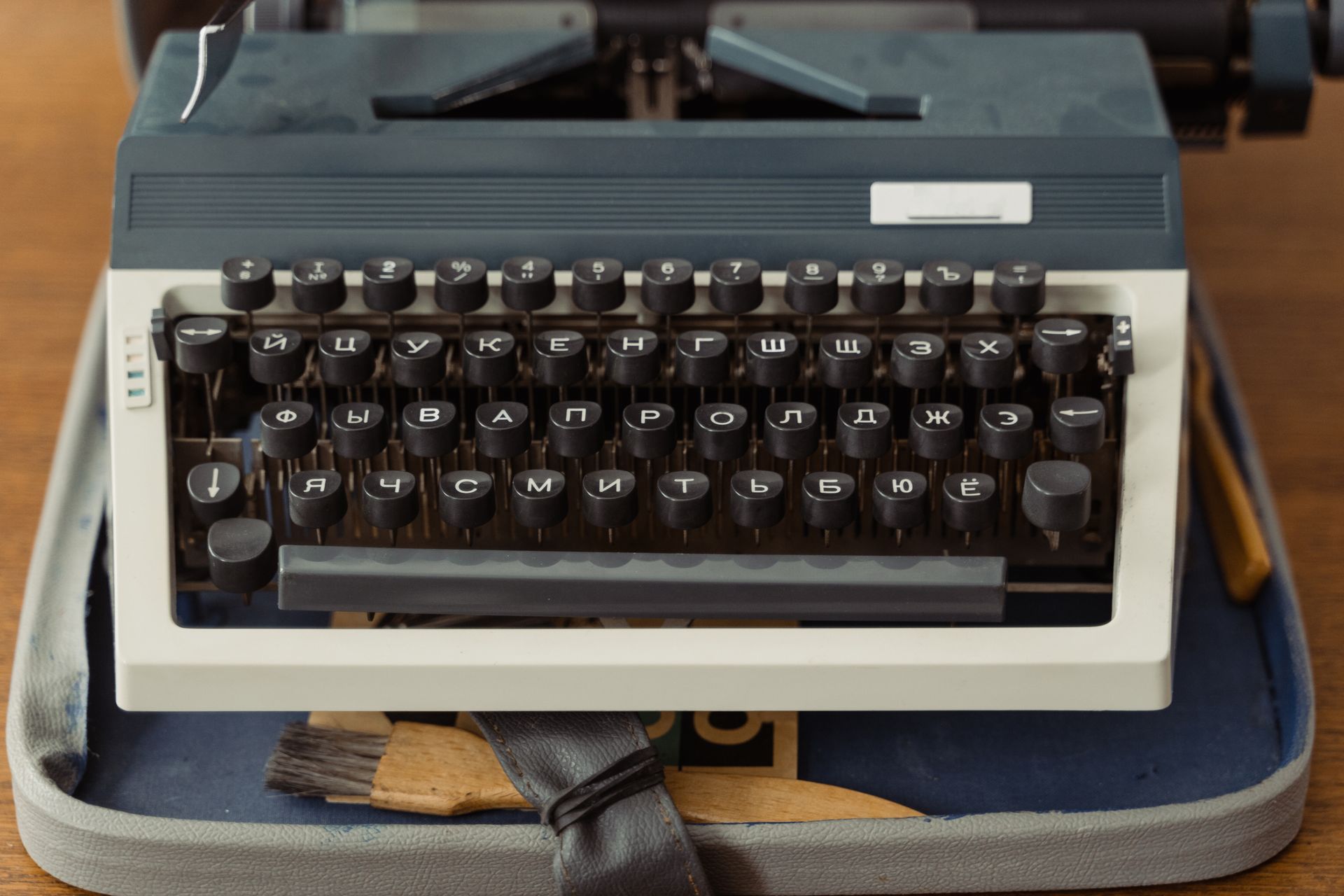 Close-up of a vintage typewriter with Cyrillic keys on a wooden table.