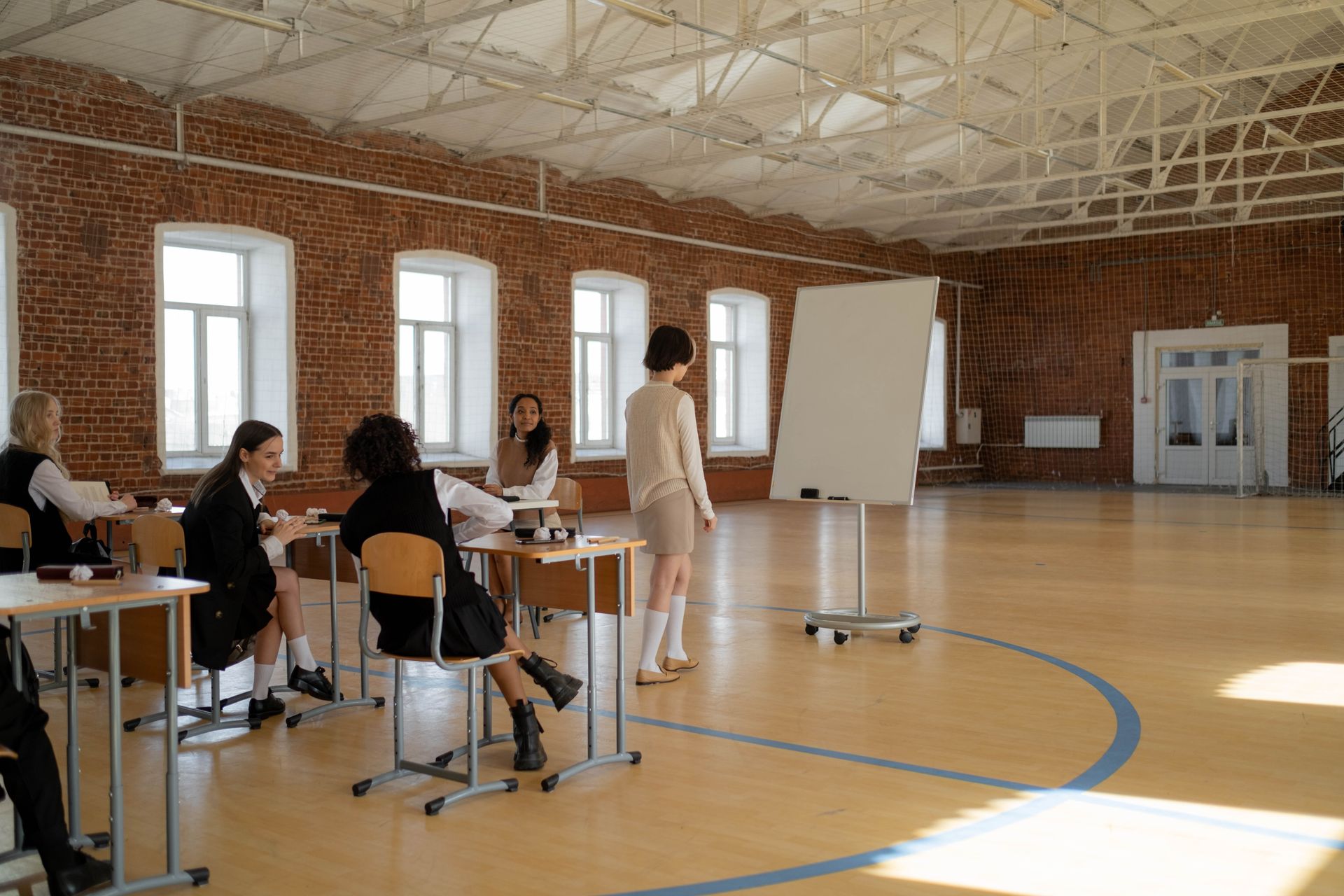 Students engaged in a lesson with a teacher in a spacious classroom