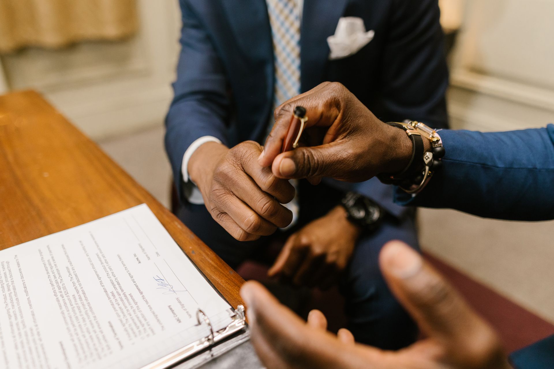 Two businessmen in suits finalize a contract, highlighting teamwork and agreement