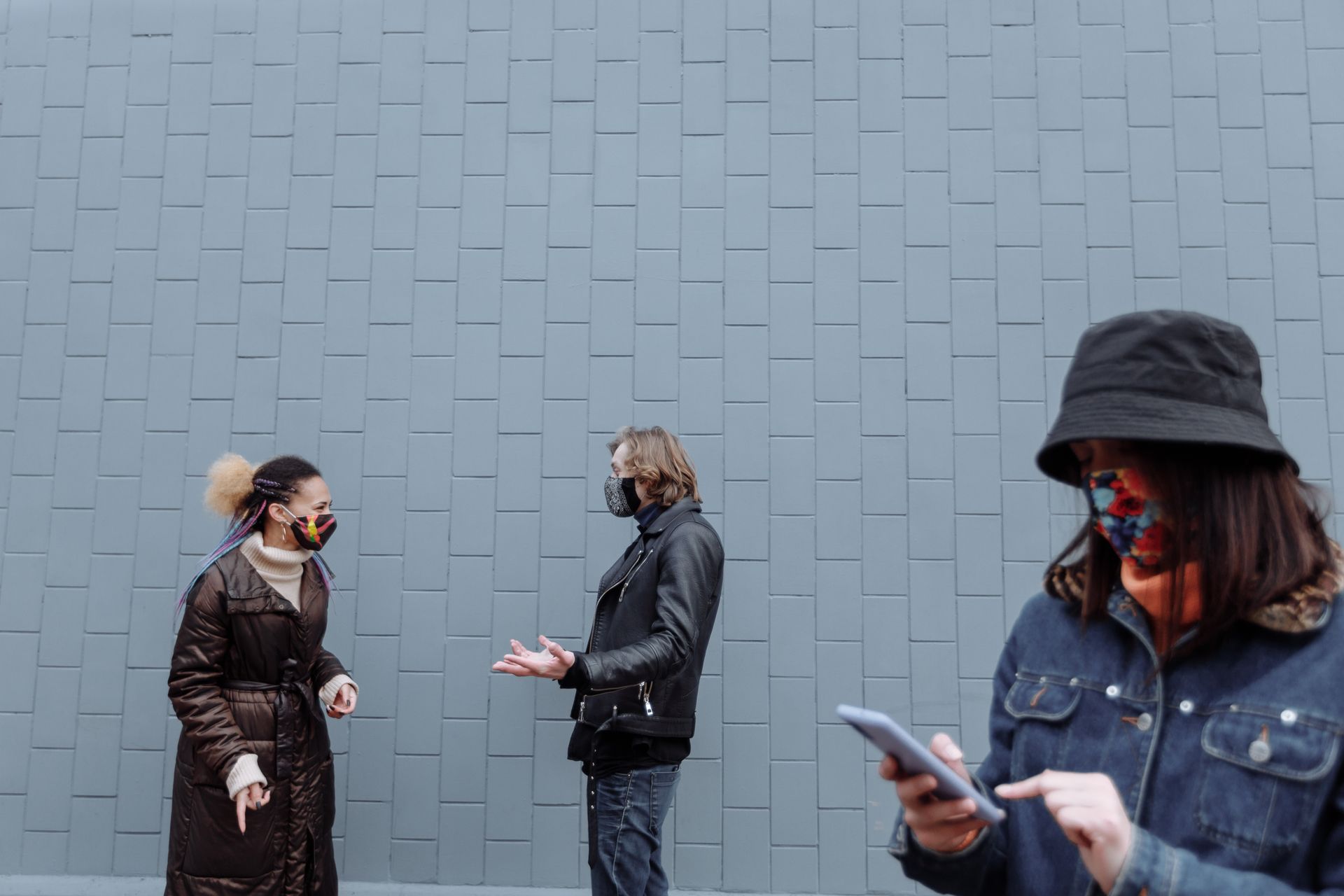 People talking on a city street beside a woman using a phone