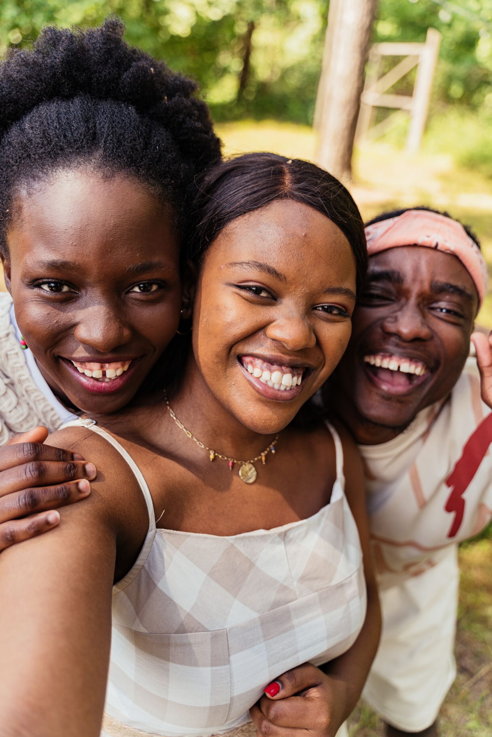 Three friends laughing and taking a selfie outdoors