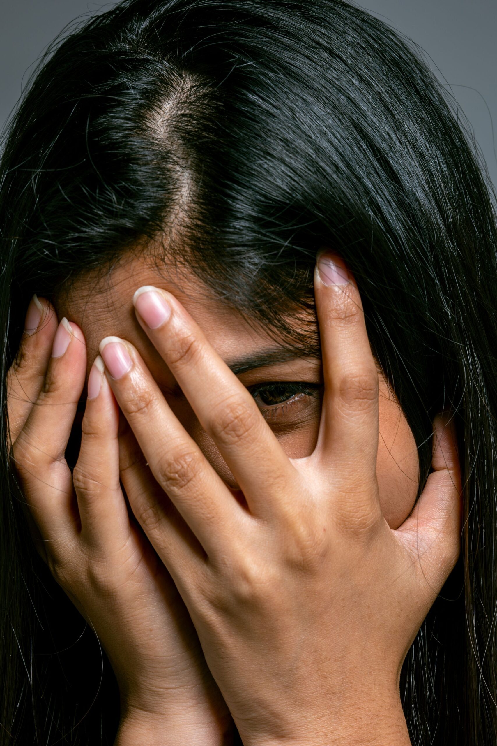Woman covering her face with her hands in embarrassment