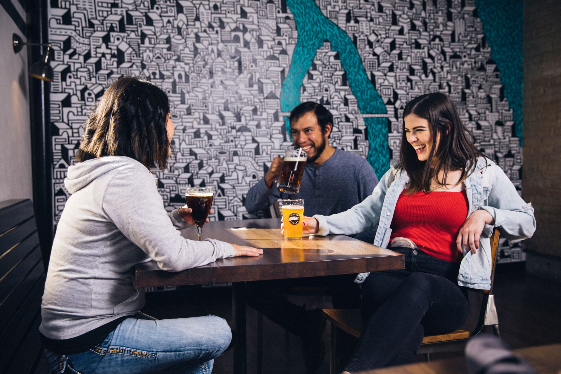 Three people sitting at a table laughing together