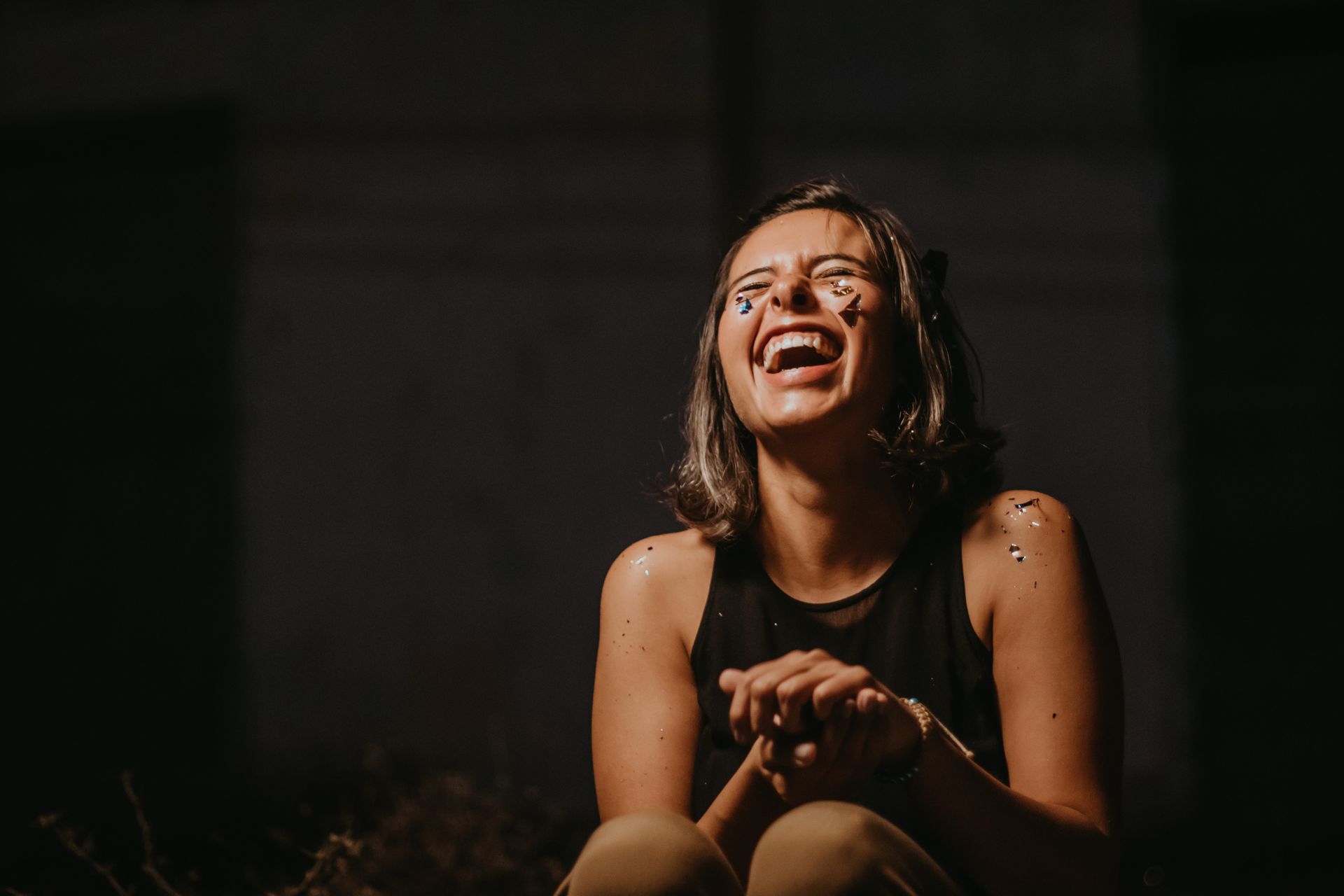 Joyful young woman laughing with confetti