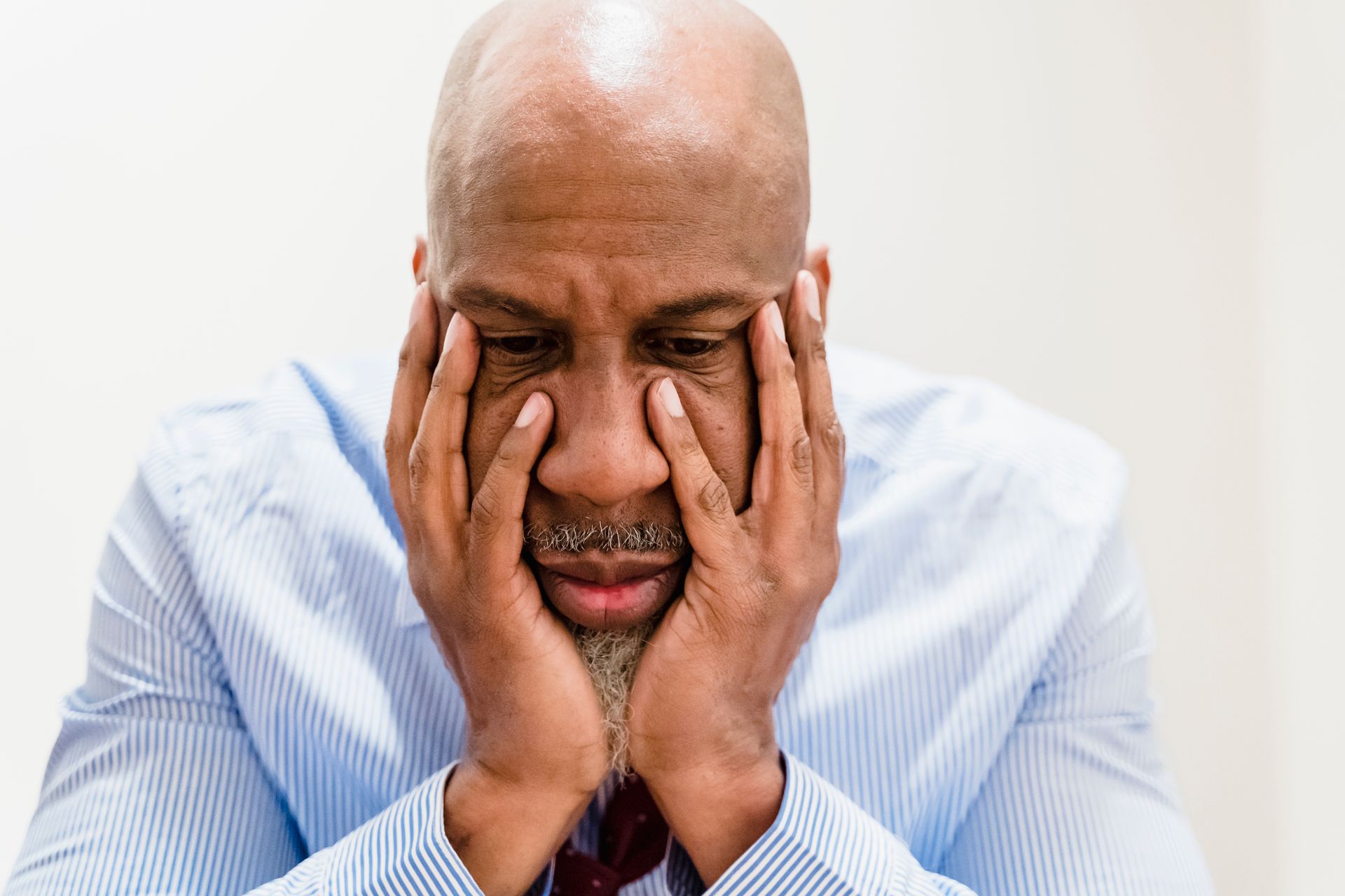 Worried man holding his face in his hands
