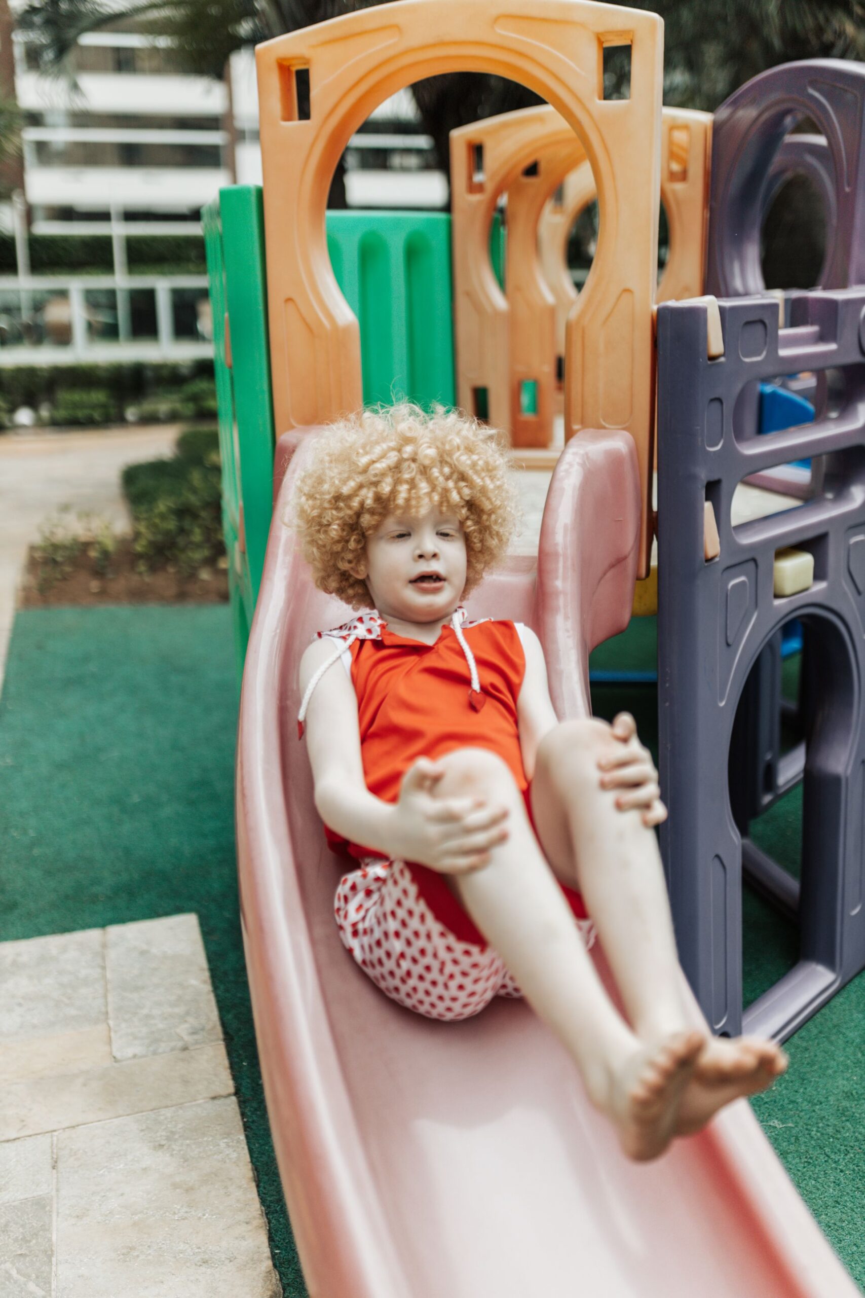 Smiling child going down a slide at a playground