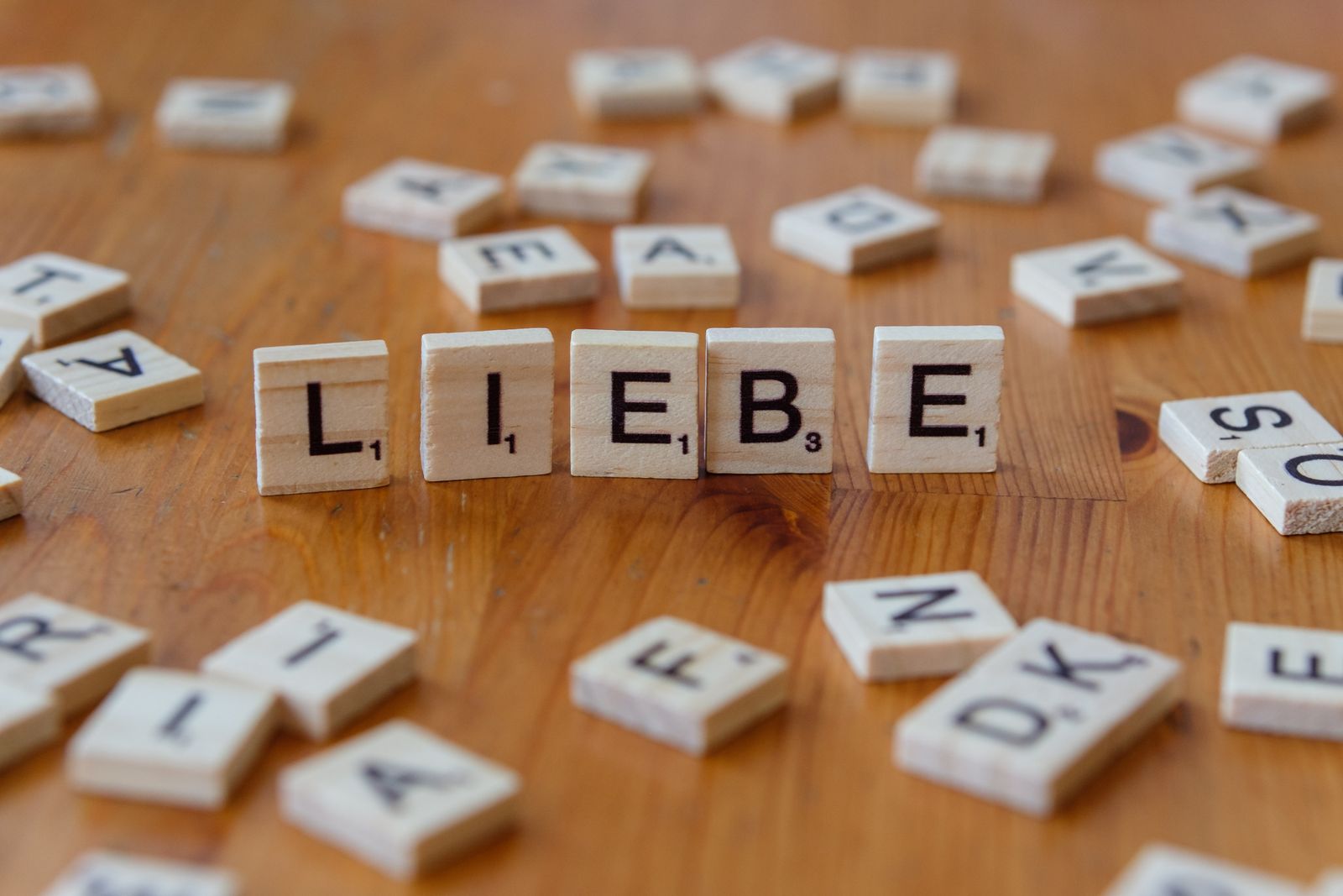 Scrabble tiles spelling the German word Liebe on a wooden surface
