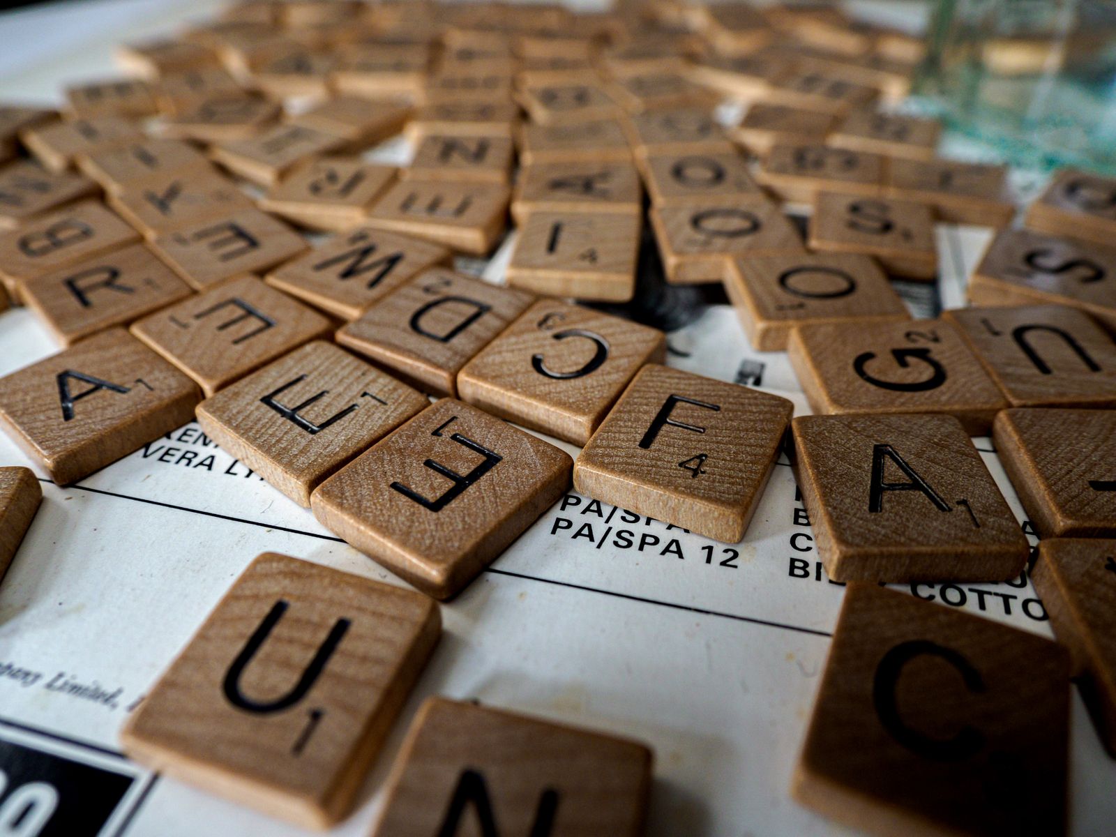 Close-up of wooden Scrabble tiles scattered on a table