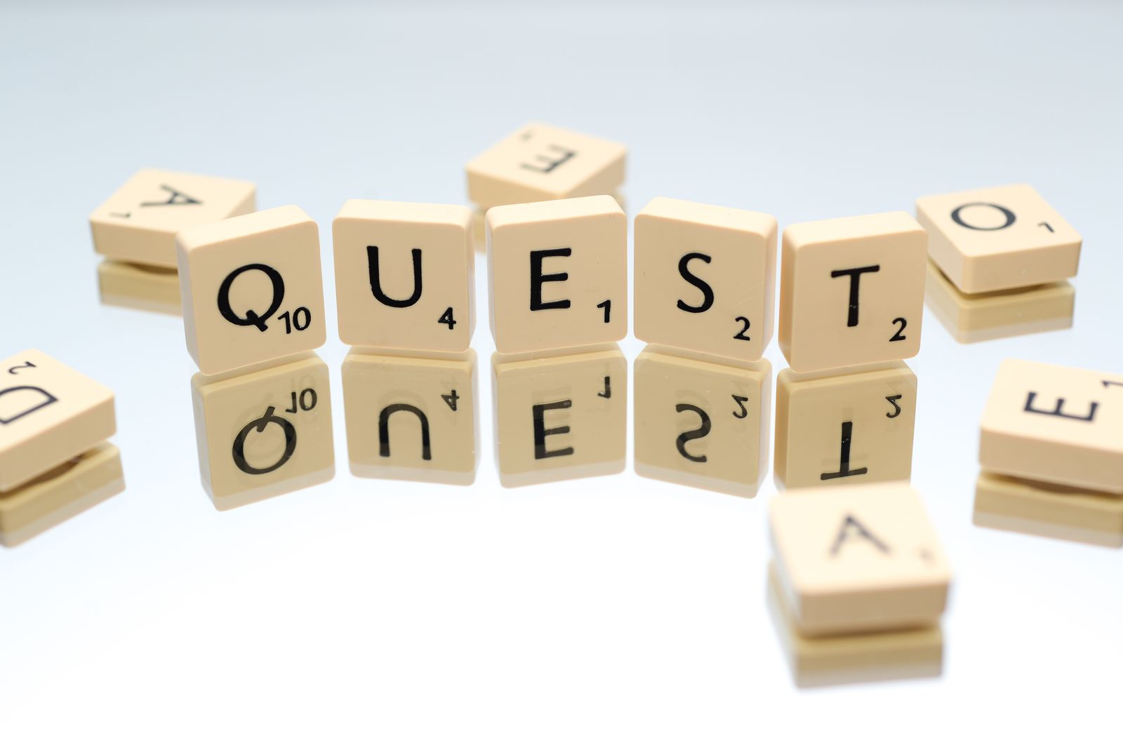 Scrabble tiles spelling the word Question on a reflective surface