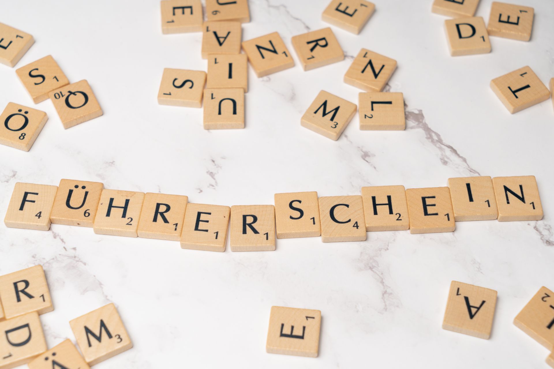 Scrabble tiles spelling Fuhrerschein on a marble surface