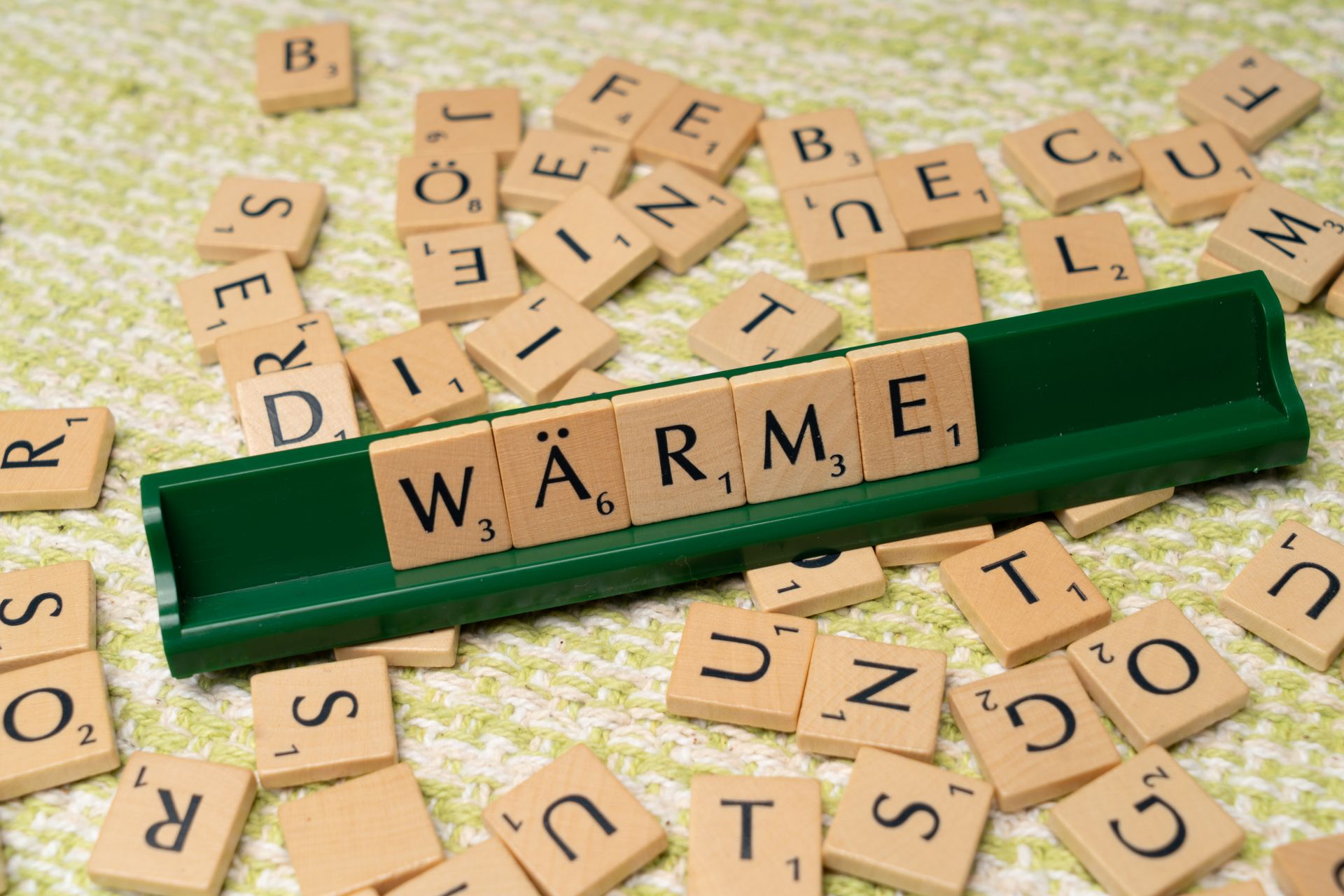 Scrabble board with the word Warme spelled out