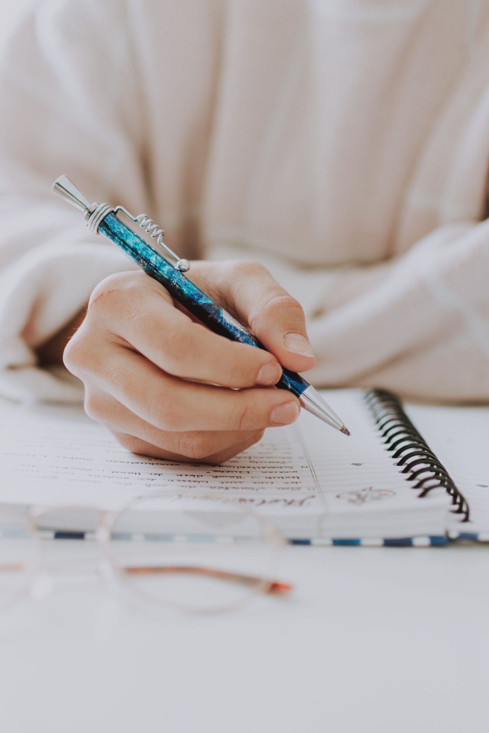 Woman writing notes in a notebook with a pen