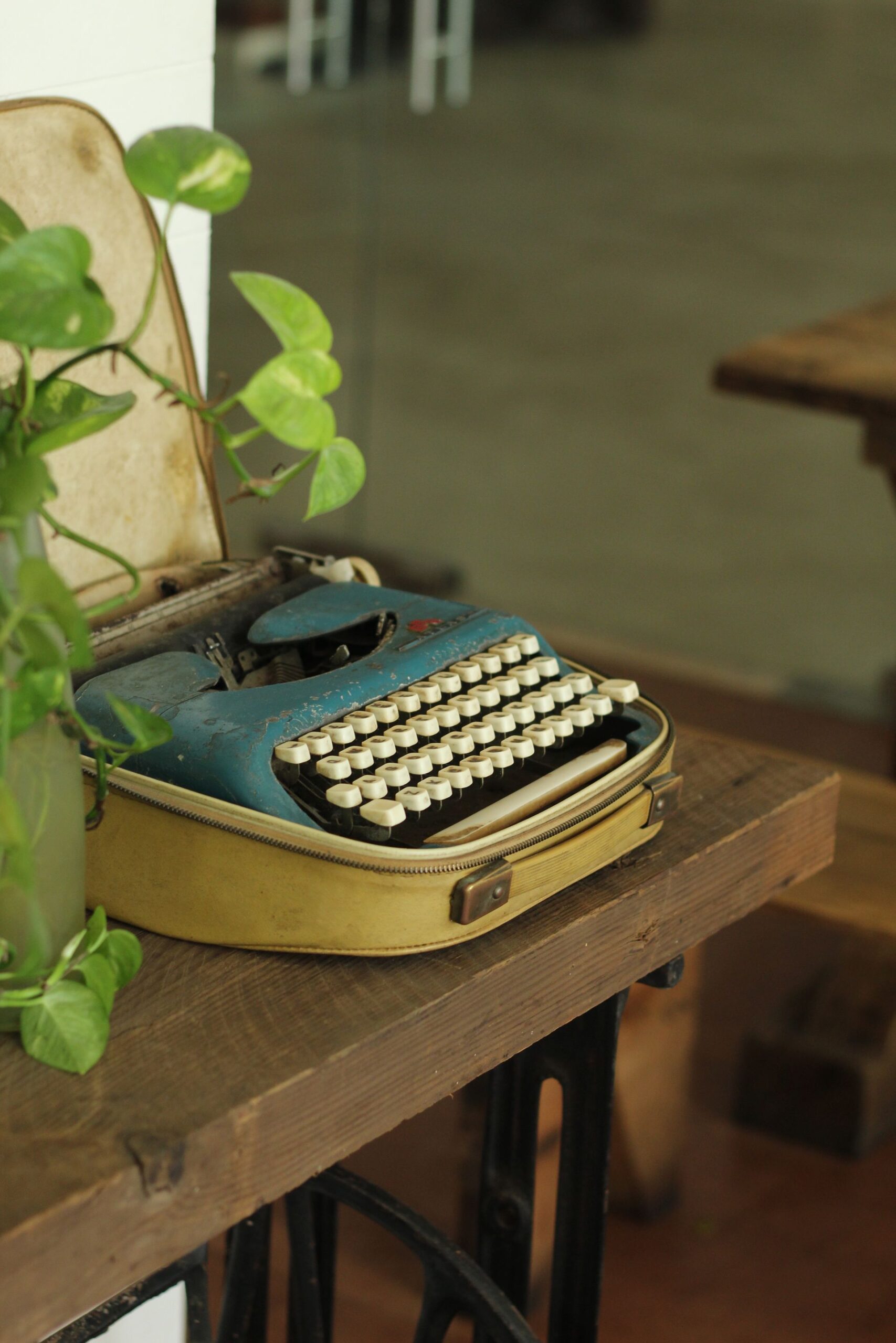 Old typewriter with lush ivy in a cozy indoor scene, perfect for retro nostalgia.
