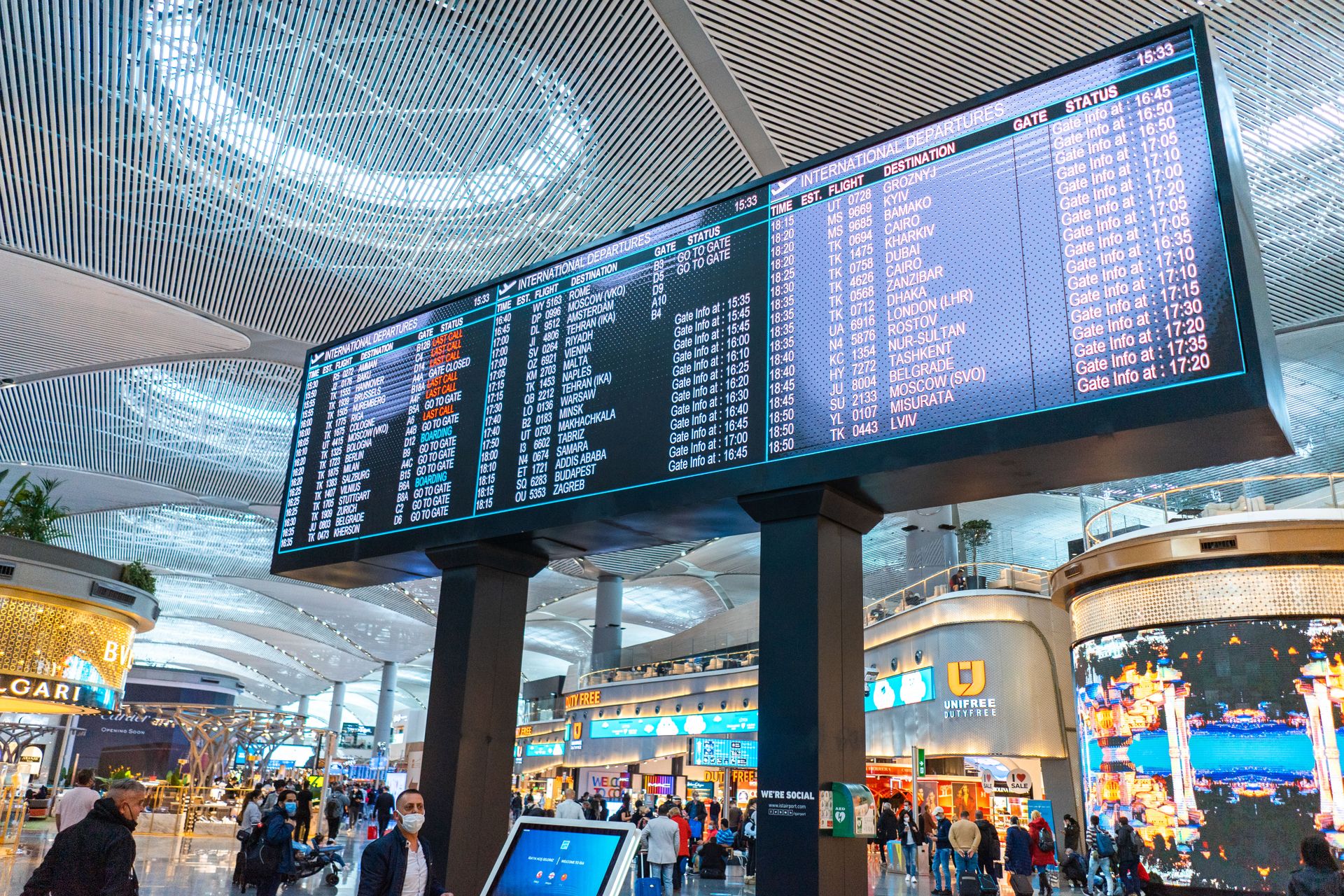 Passengers walking through a busy airport departure hall