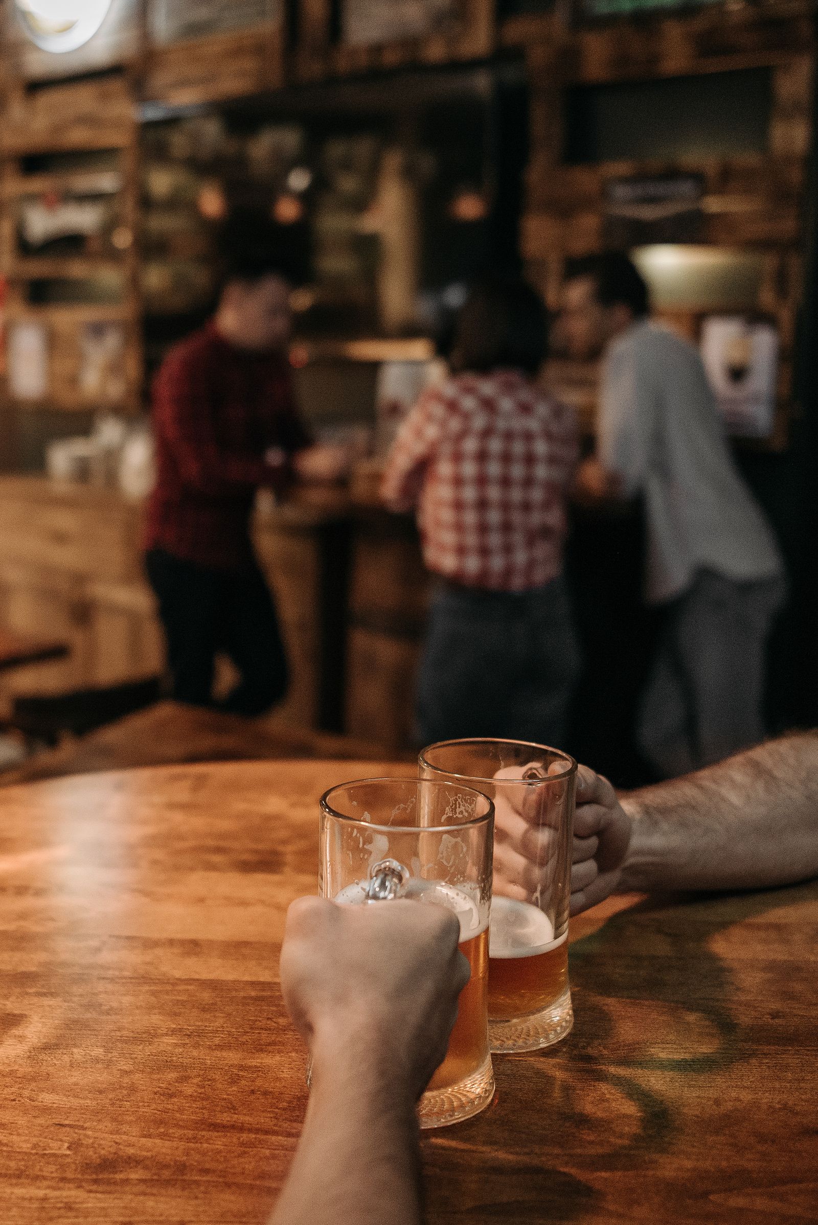 Two people enjoying draft beer in a rustic bar
