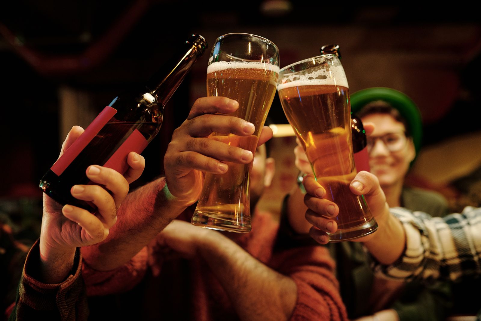 Friends toasting with beer glasses in a lively pub