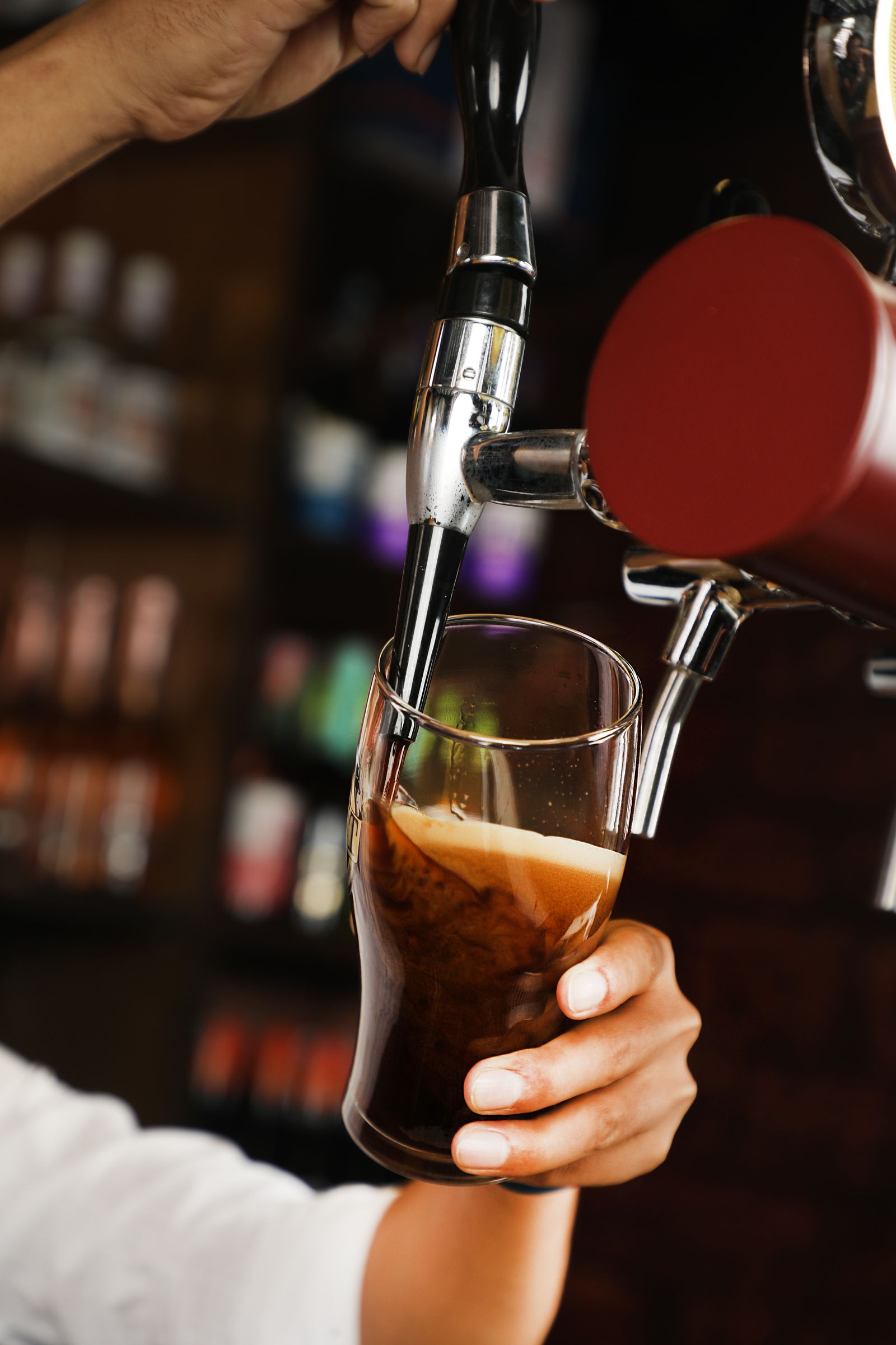 Bartender pouring draft beer into a glass