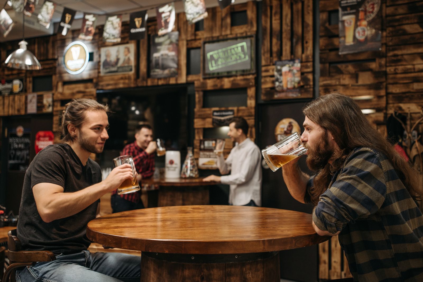 Two friends tasting beer in a rustic bar