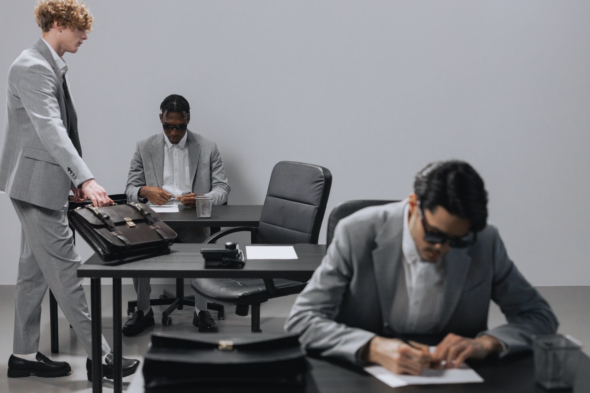 Business office with diverse employees in gray suits working at desks in an indoor setting
