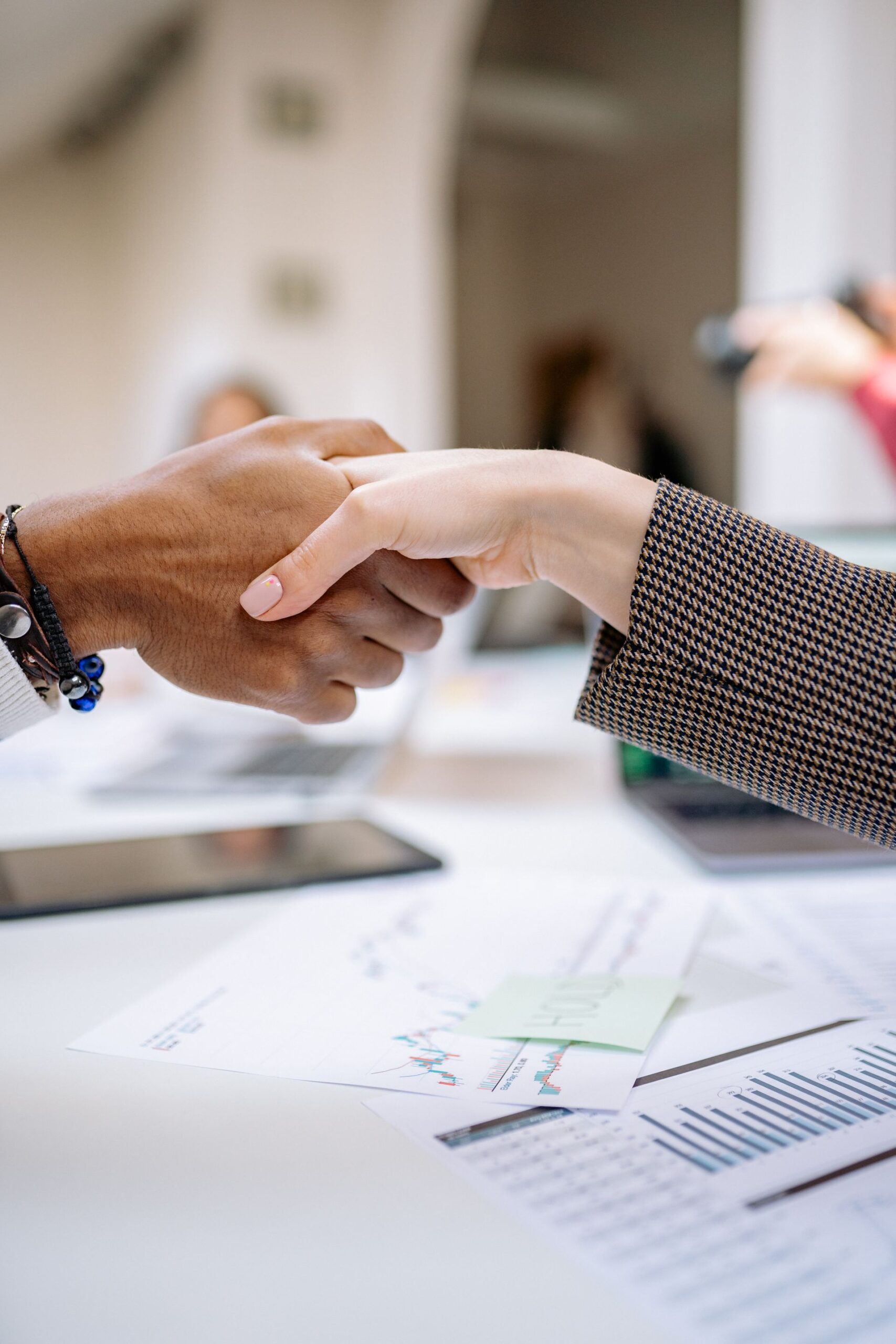 Close-up of a professional handshake over business documents, symbolizing partnership and agreement