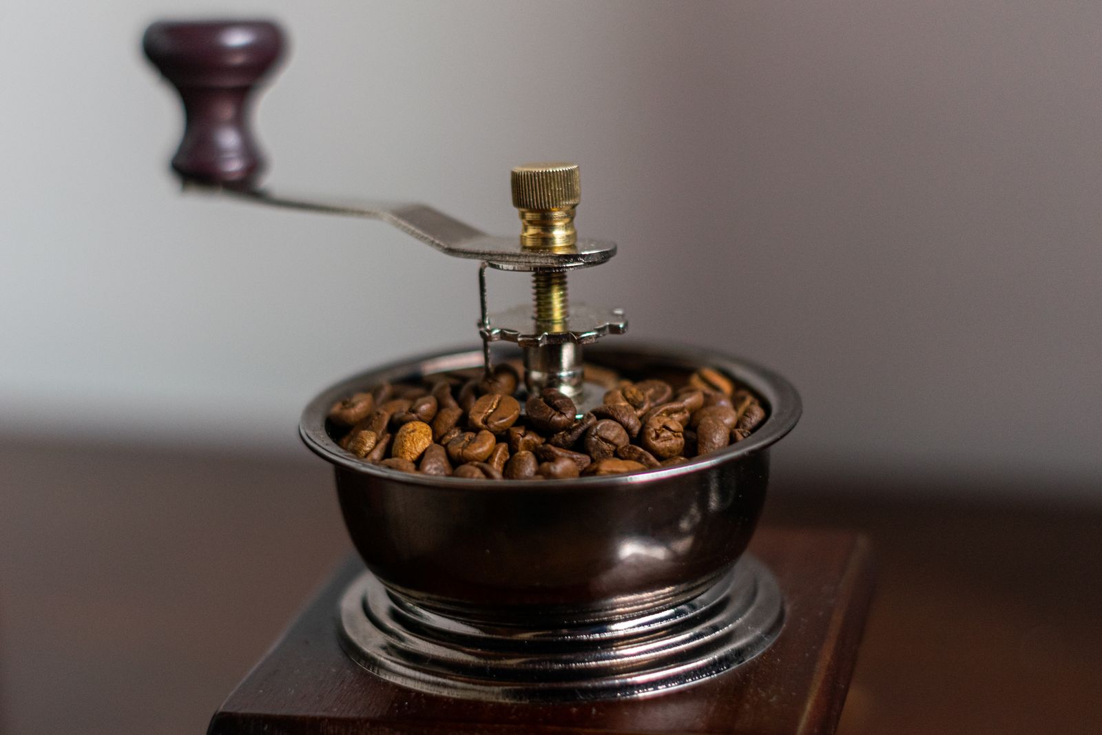 Vintage manual coffee grinder filled with fresh roasted coffee beans