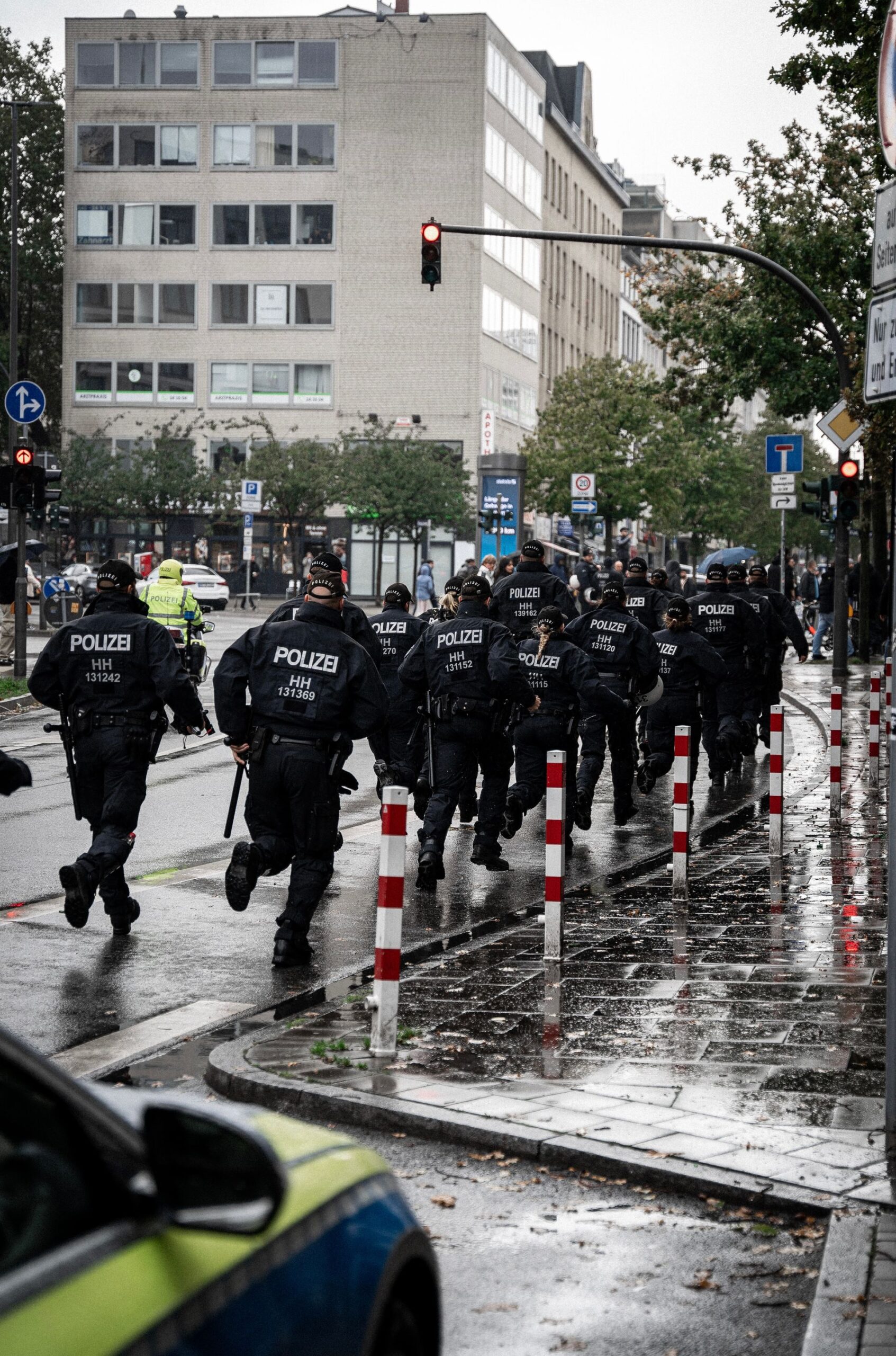 Police officers running down a rainy street in Hamburg