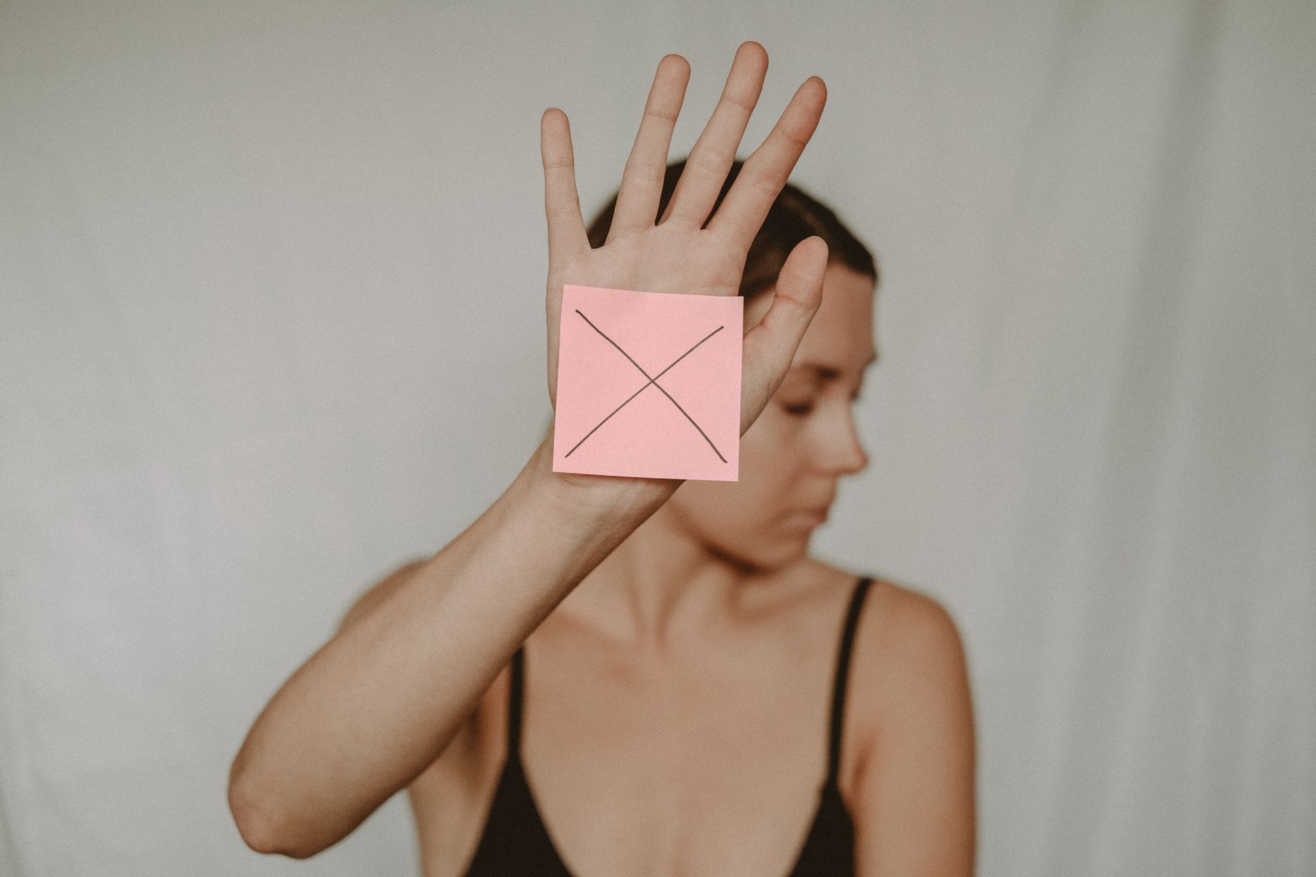 Woman holding a paper with a cross sign