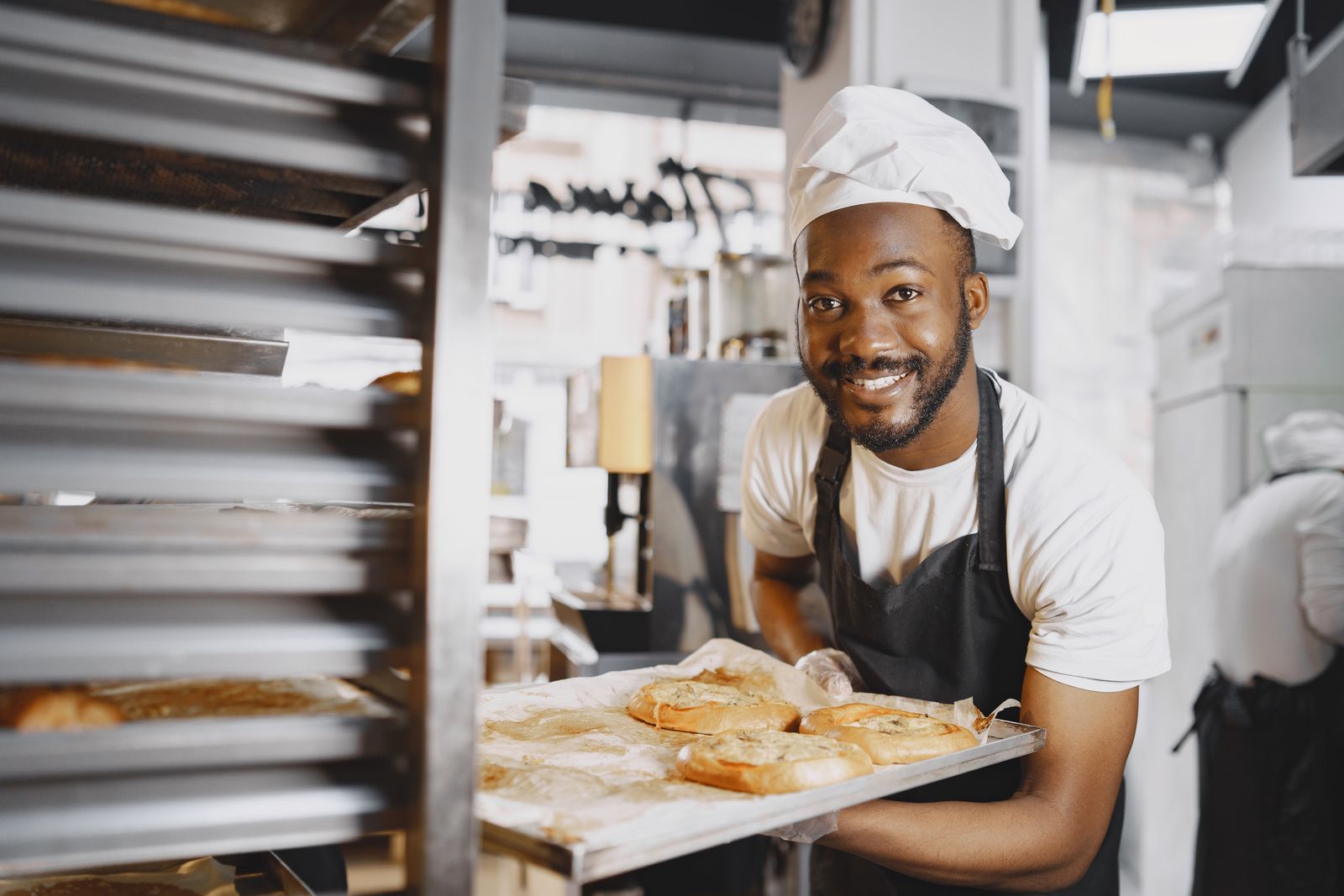 Baker holding a tray of freshly baked goods