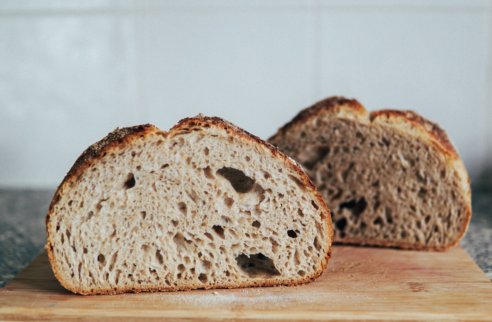 Freshly baked rustic artisan bread loaves on a wooden cutting board