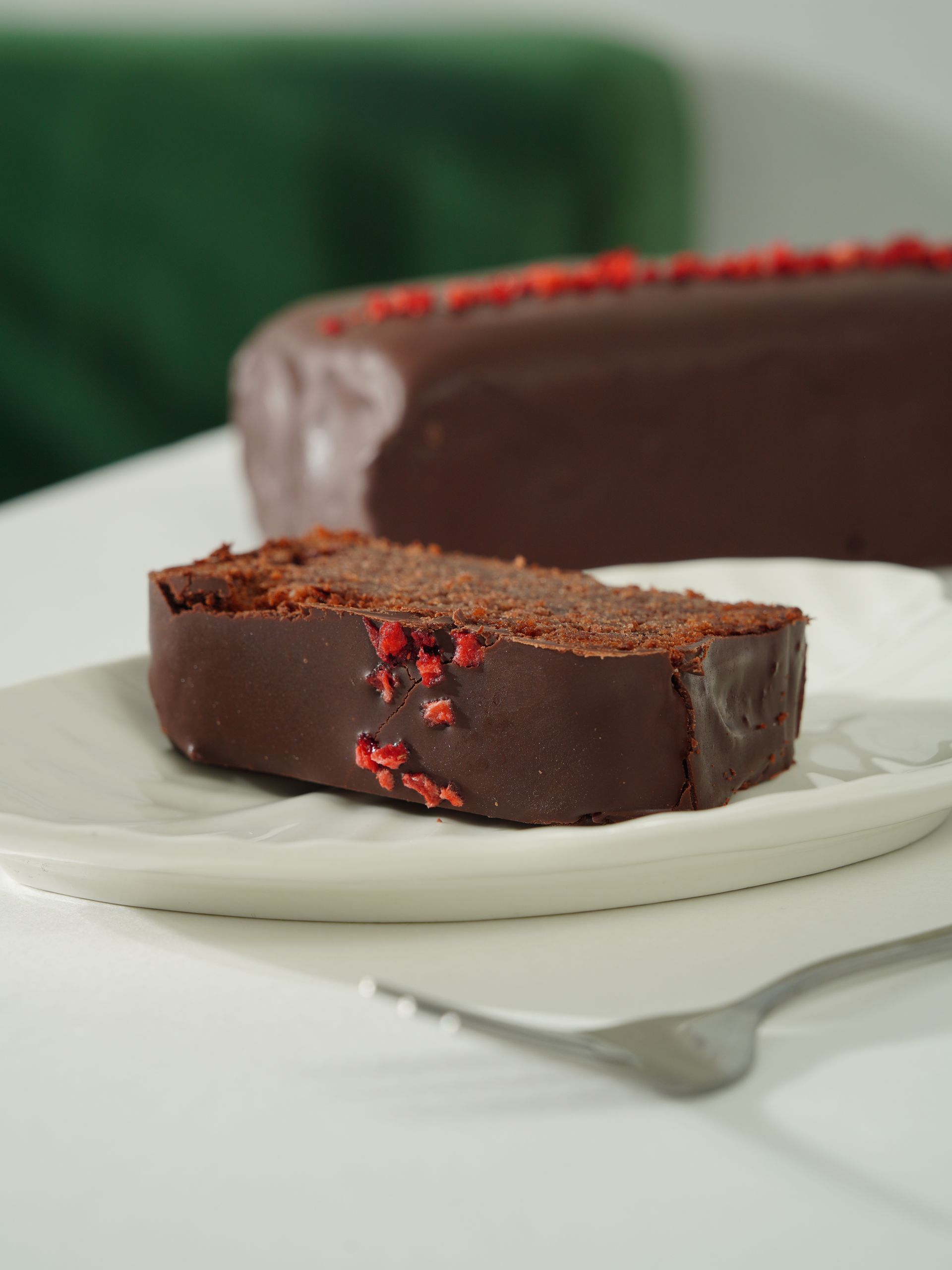 Close-up of a rich chocolate cake slice with dried berries