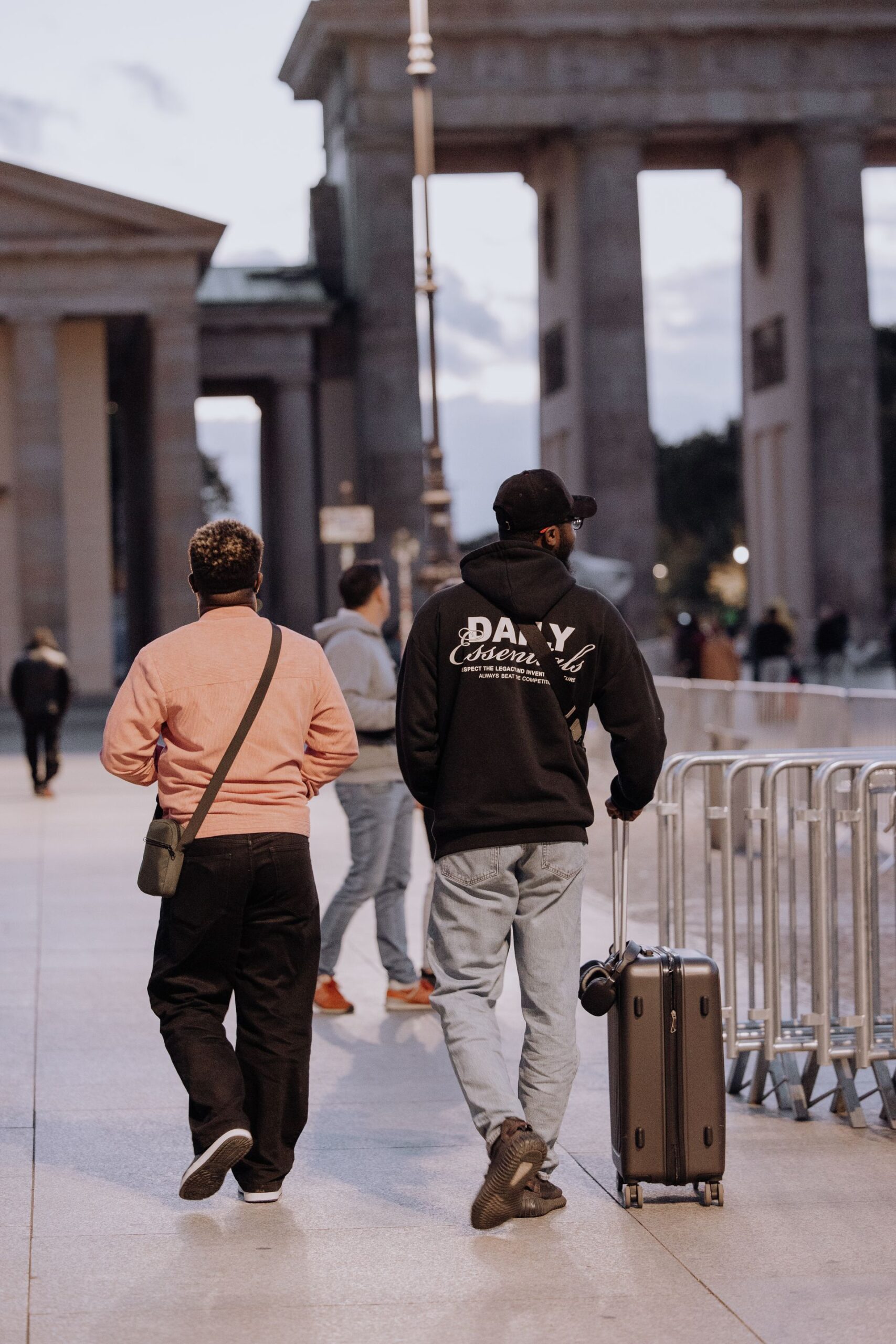 Two tourists walking near the Brandenburg Gate in Berlin
