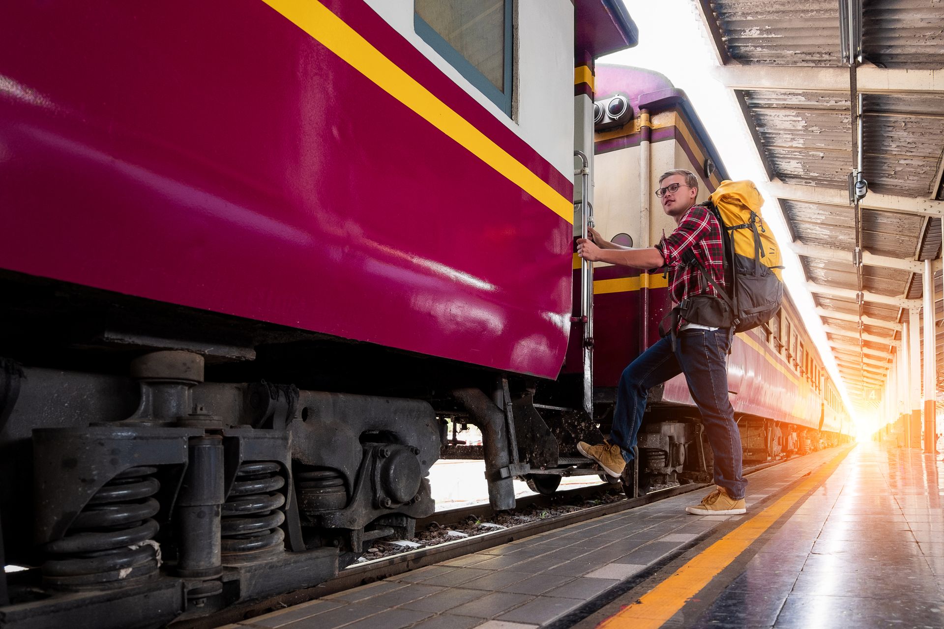 Backpacker boarding a train at a city railway station