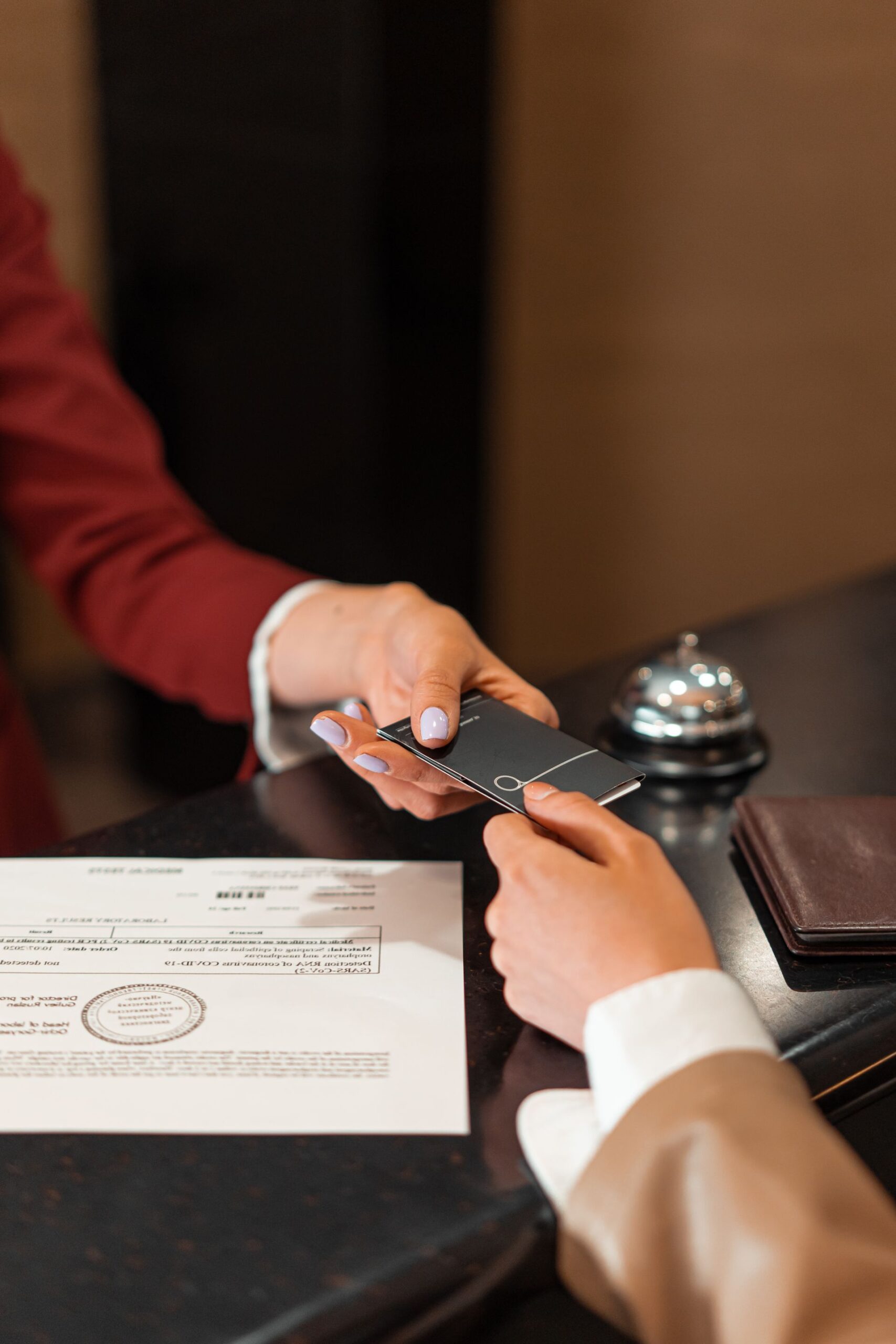 Hotel receptionist handing a key card to a guest