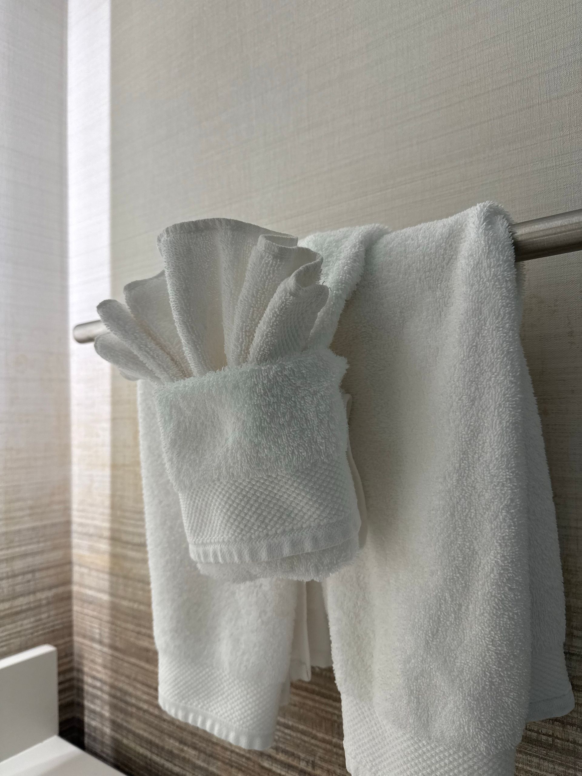 White towels arranged in a modern hotel bathroom