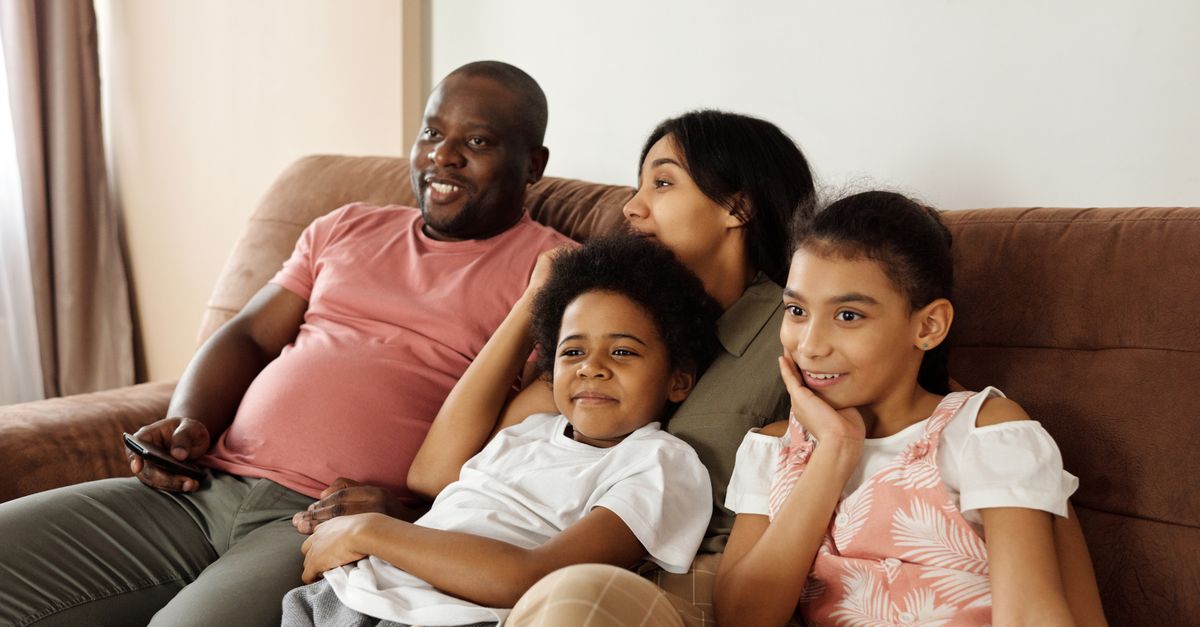 Happy family sitting on a couch watching TV