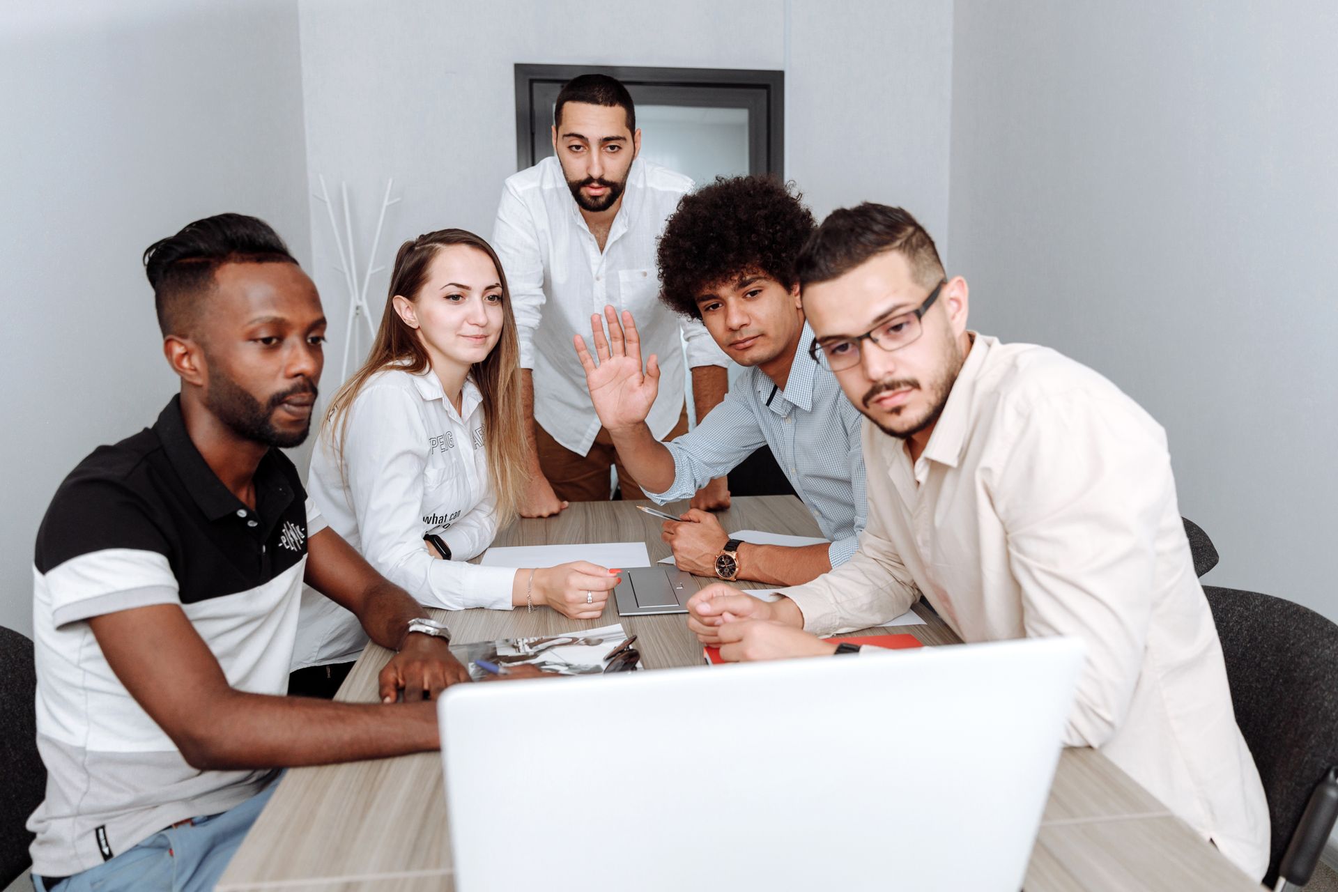 Diverse team collaborating around a laptop in a modern office