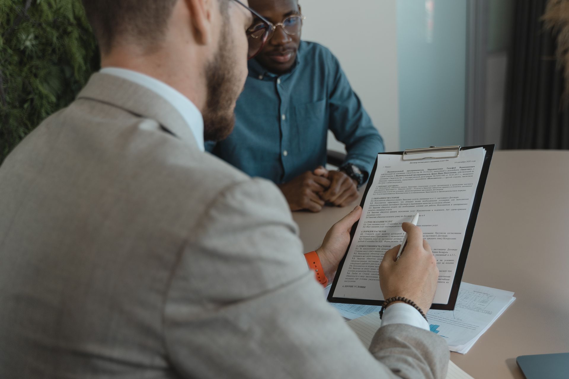 A recruiter reviews a candidate's documents during a job interview in a modern office setting