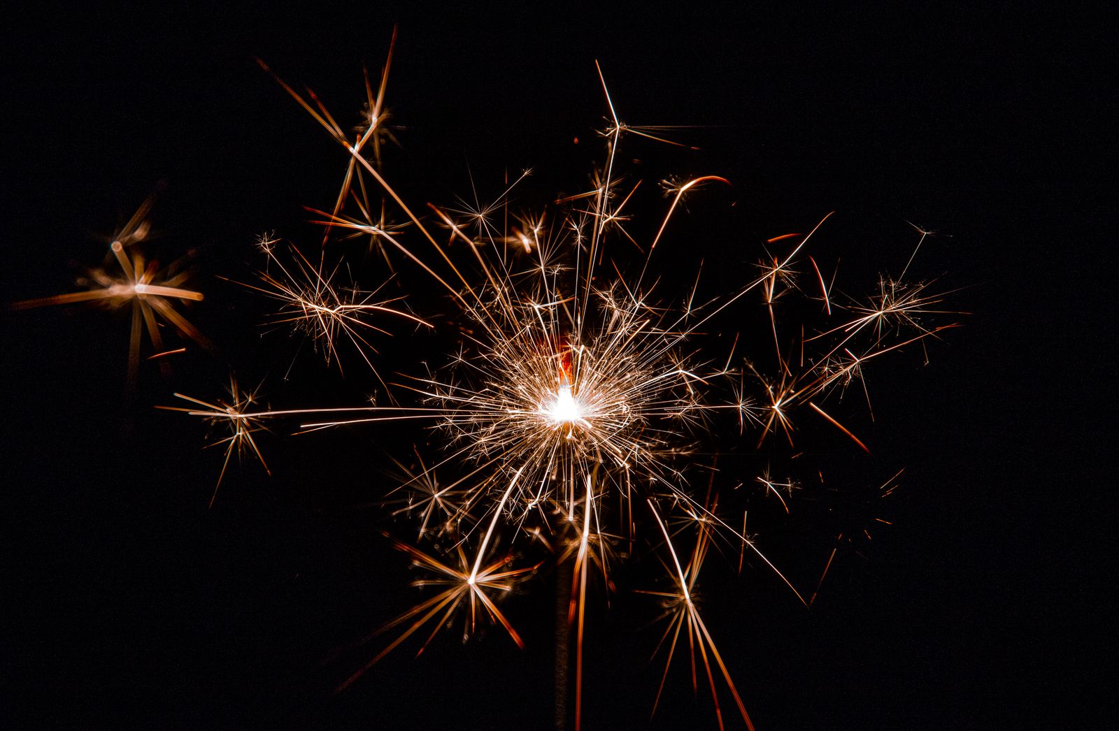 Close-up of bright sparkler sparks glowing in the dark night