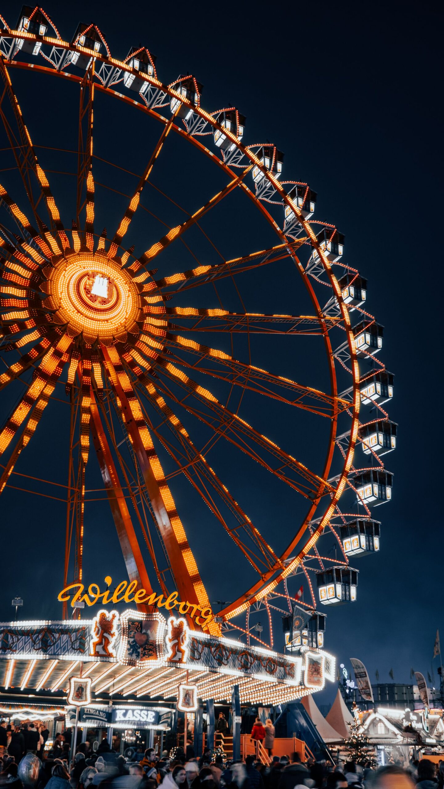 Illuminated ferris wheel at a festive fairground at night
