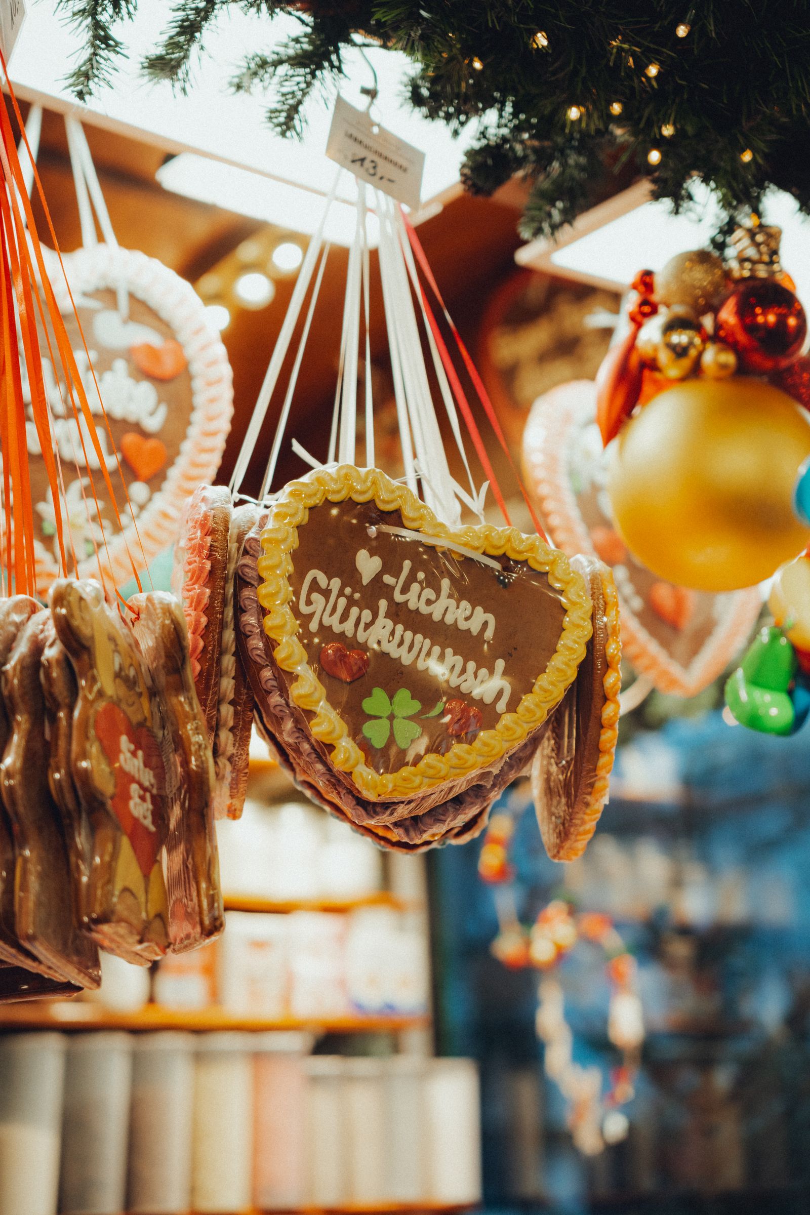 Colorful gingerbread hearts with German text hanging at a festival market
