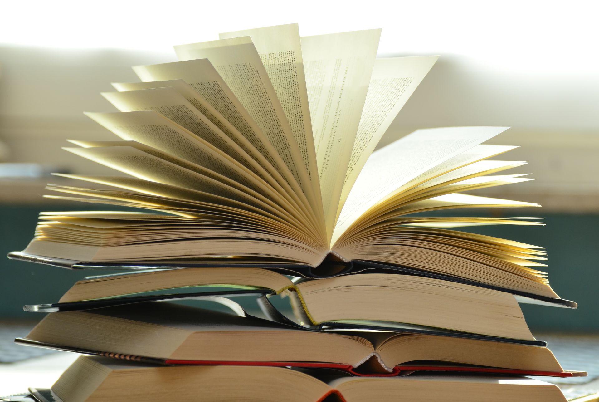 Stack of open books with pages fanned out