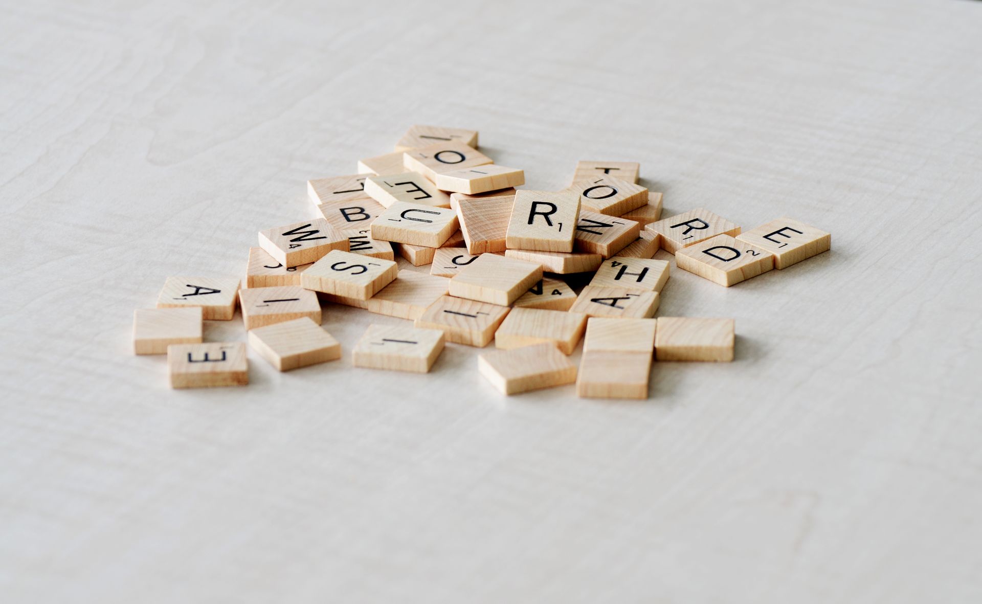 Close-up of wooden letter tiles scattered on a light table